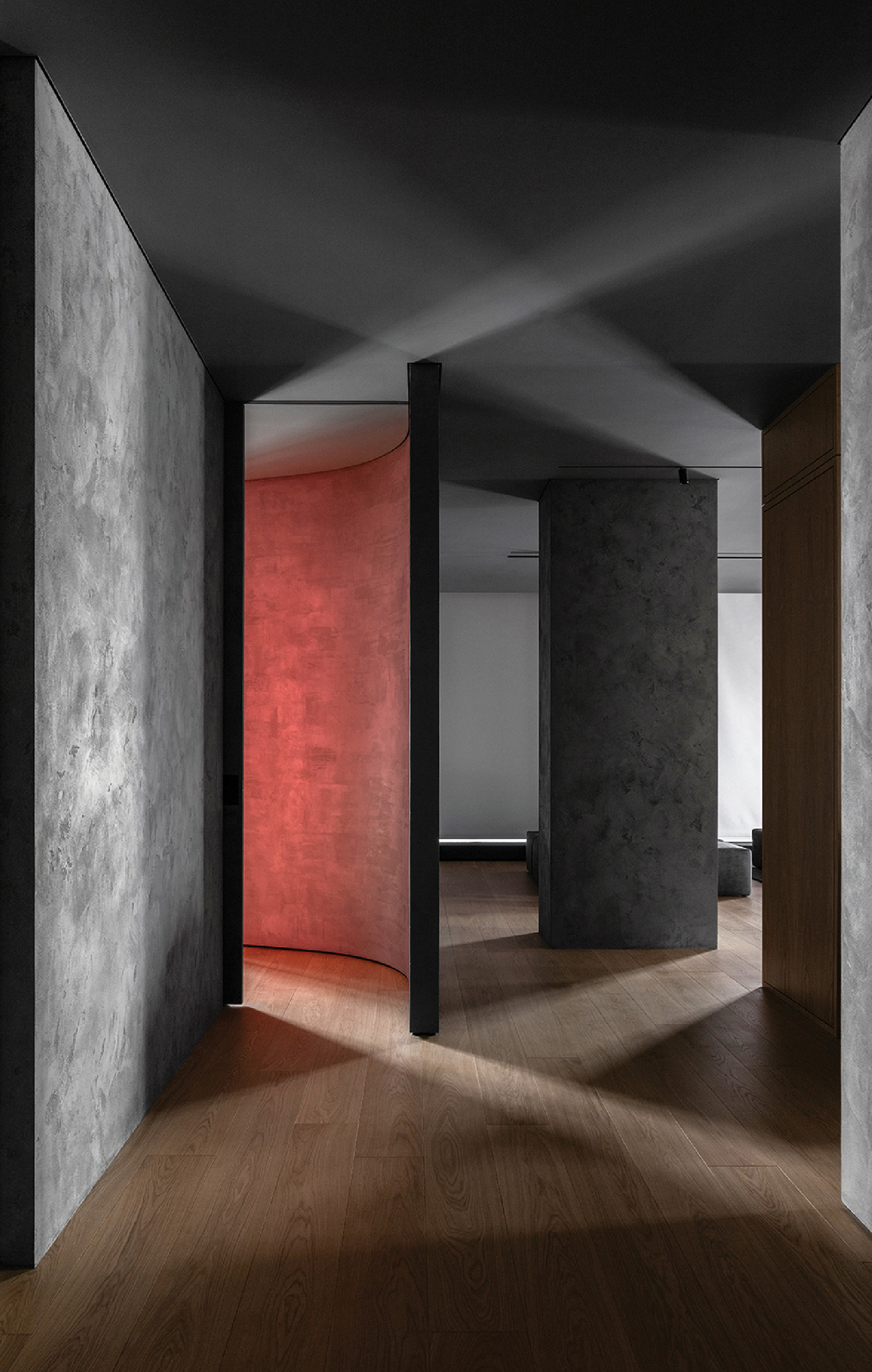 A room with a wooden floor and a red wall.