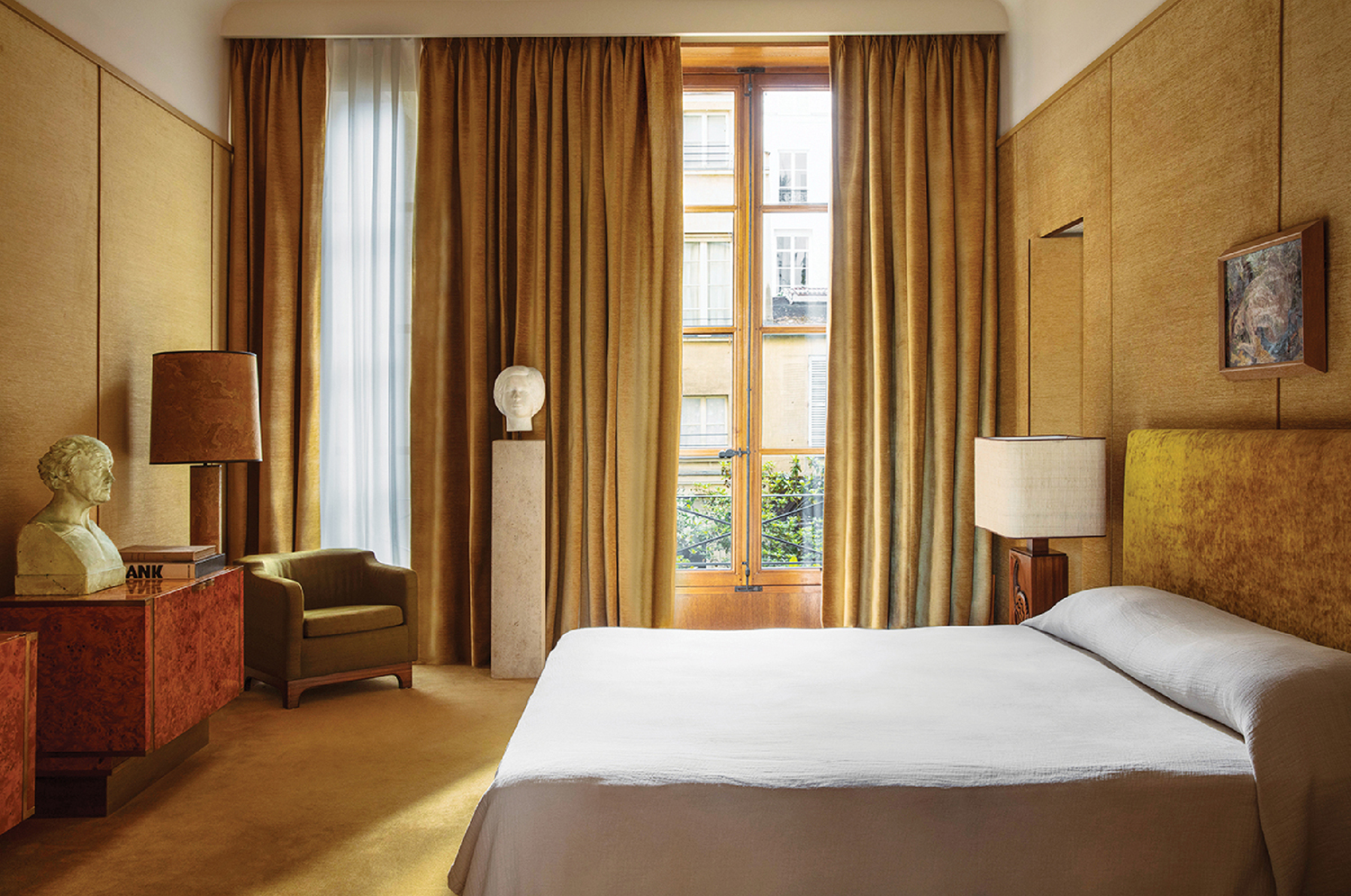 A bedroom with a bed and a chair.