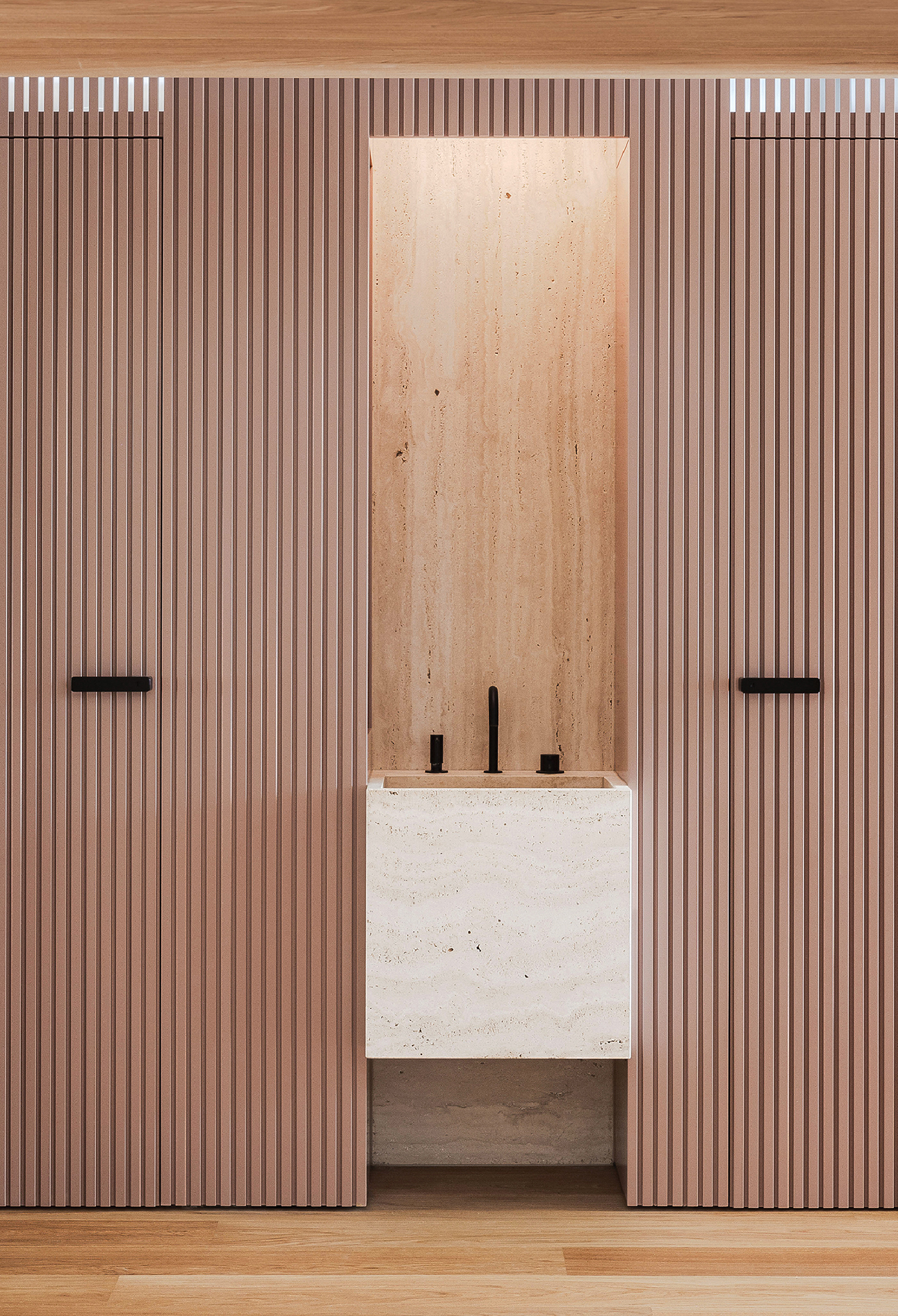 A room with a wooden wall and a white sink.