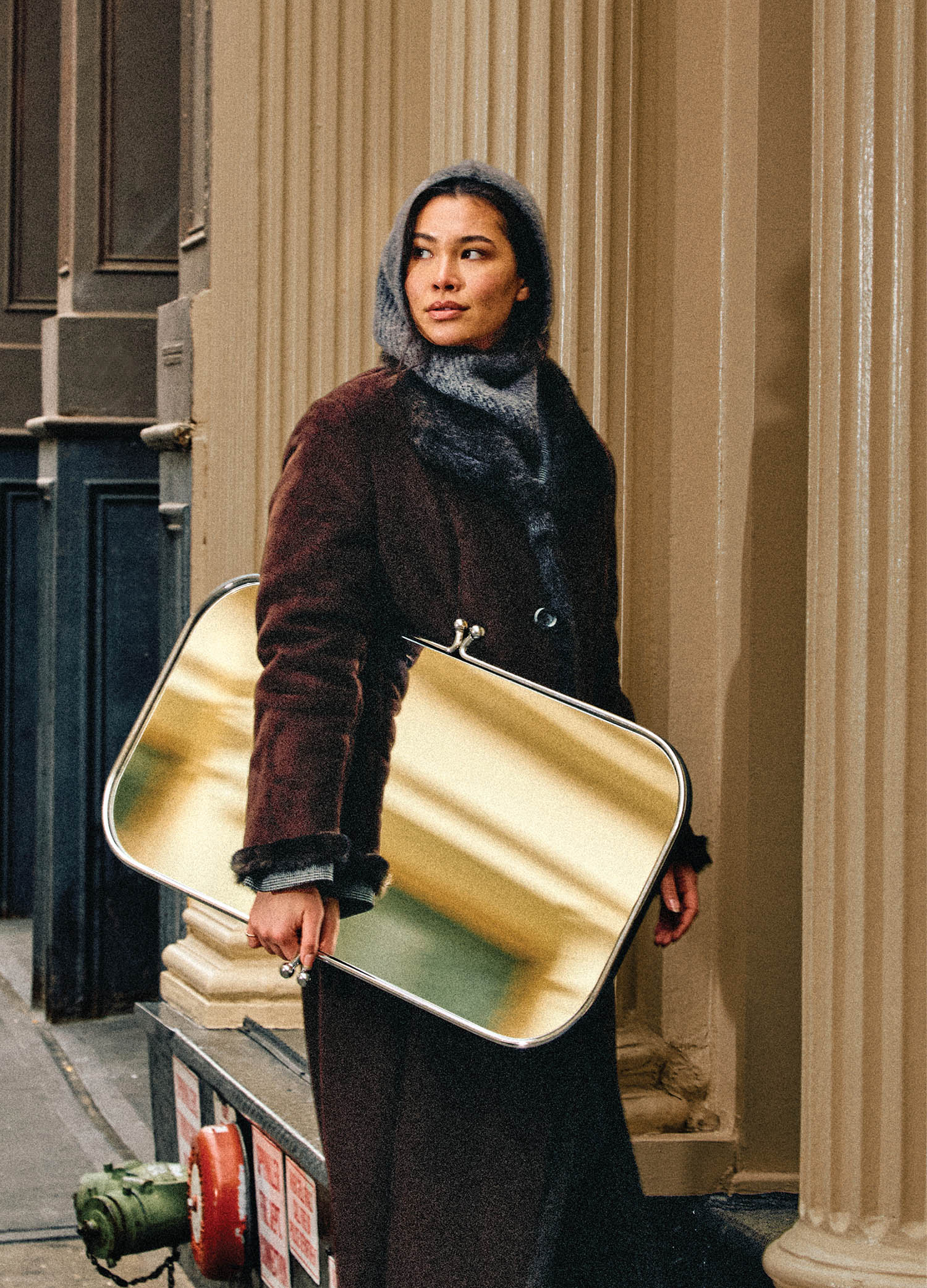 A woman in a coat and a suitcase.