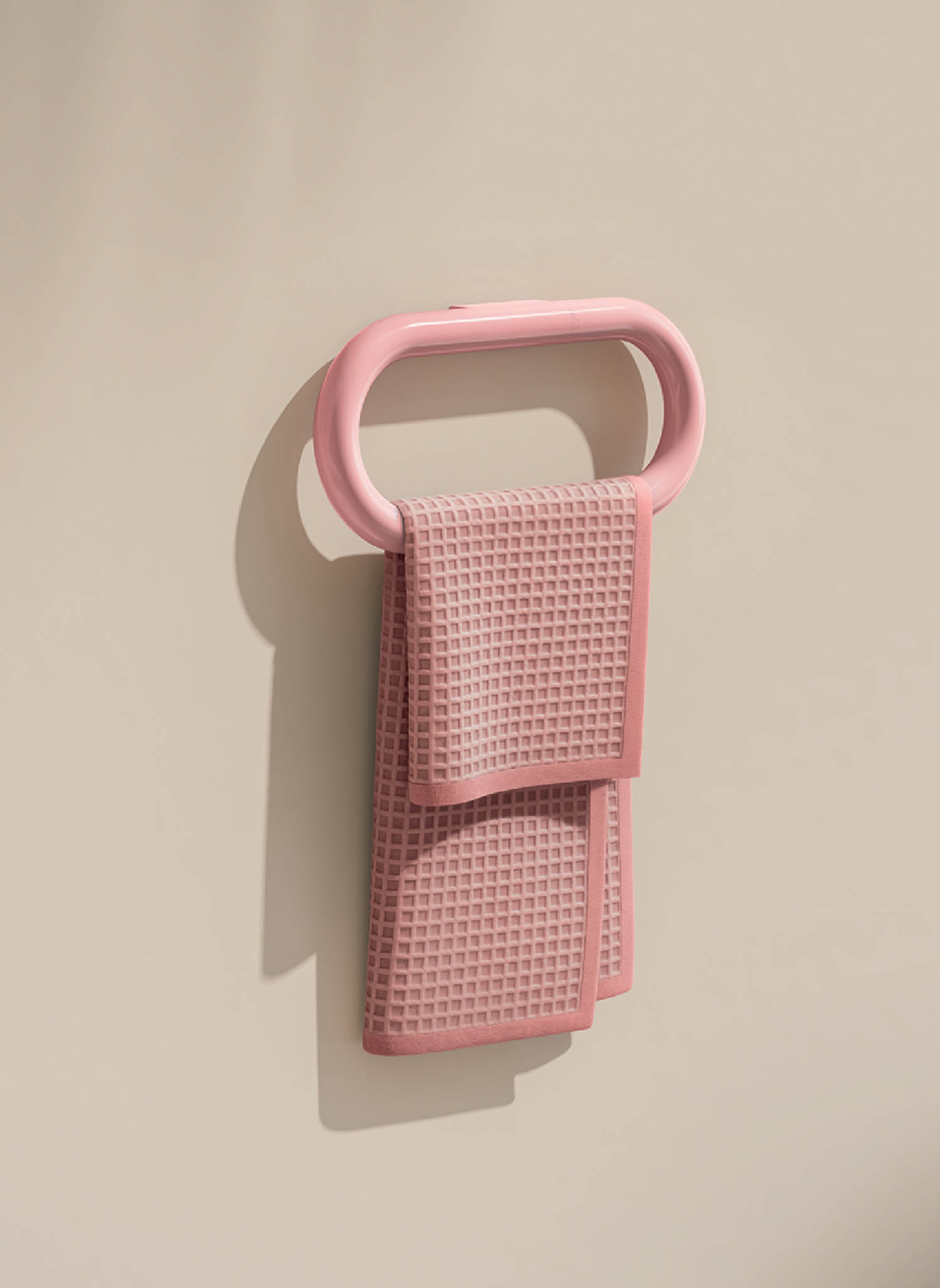 A pink phone holder hanging on a wall.