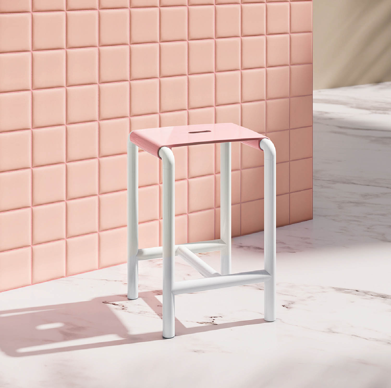 A pink and white stool in front of a pink tiled wall.