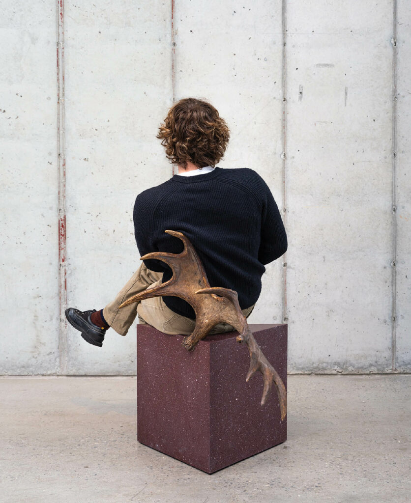 A person sitting on a box with a dog.