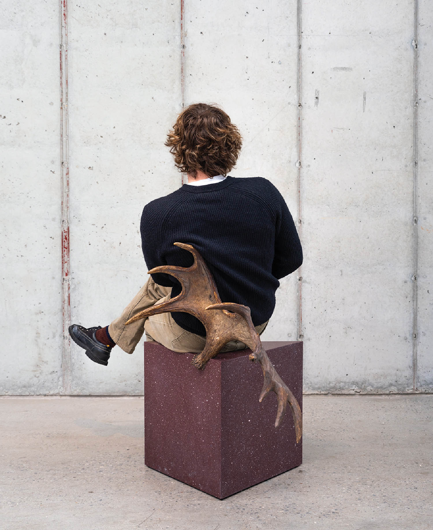 A person sitting on a box with a dog.