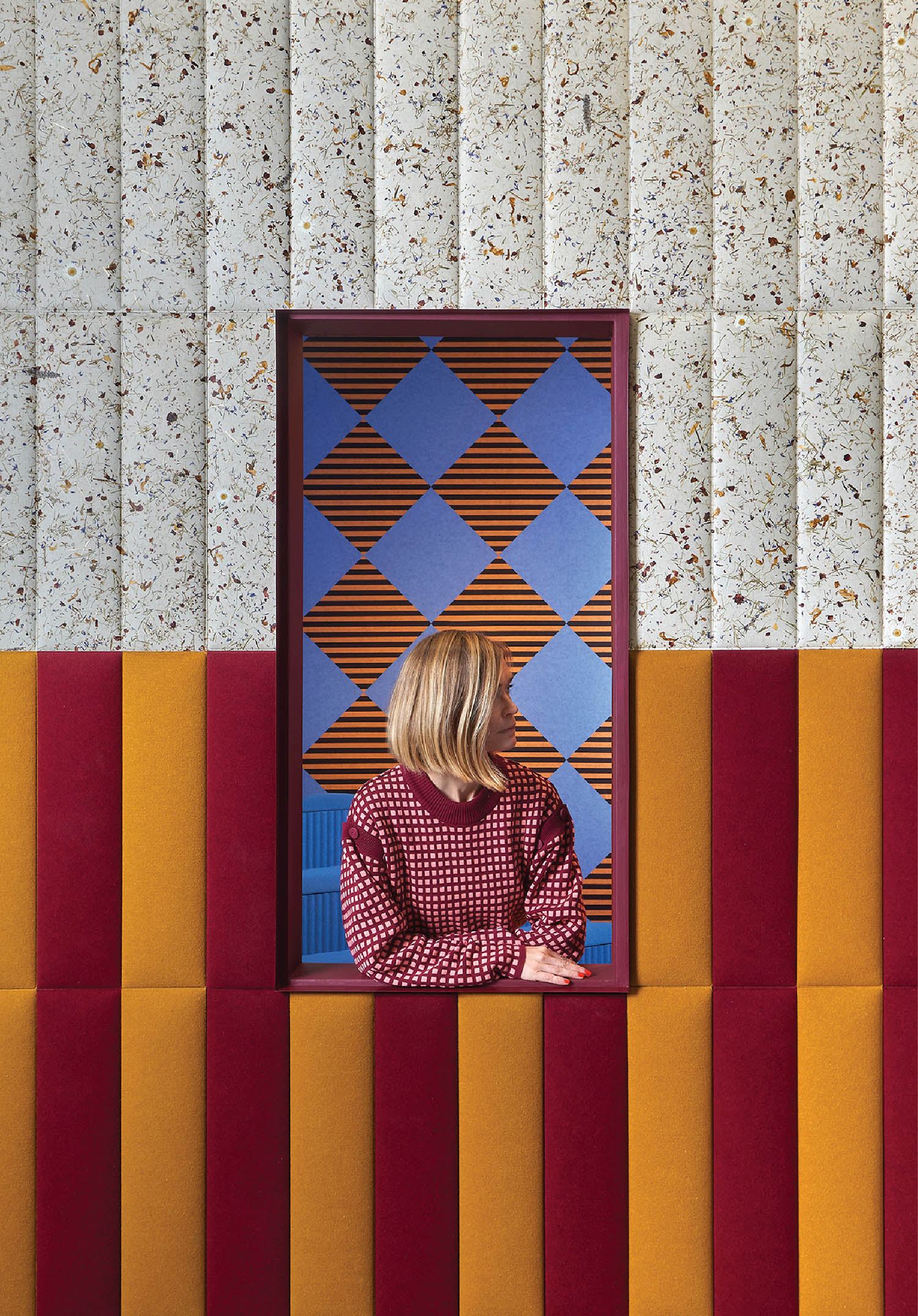 A woman looking at herself through a window.