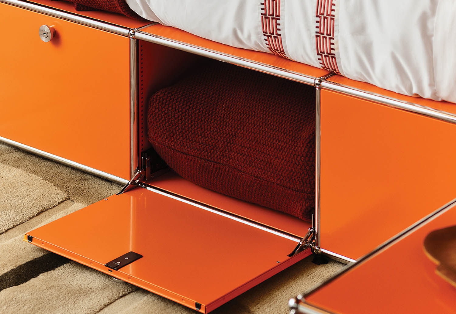 A bed with a red headboard and a white pillow.