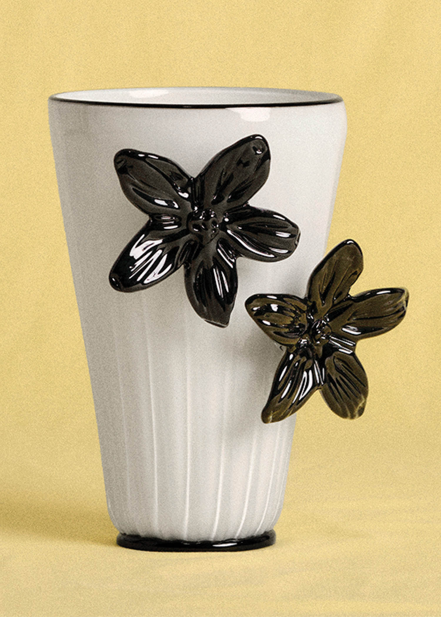 A white vase with black flowers.