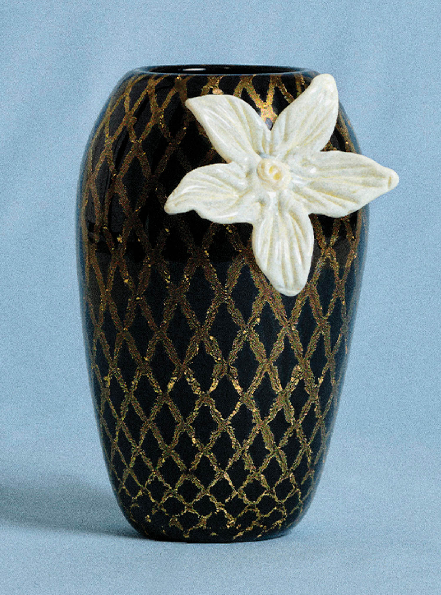A black vase with a white flower on it.