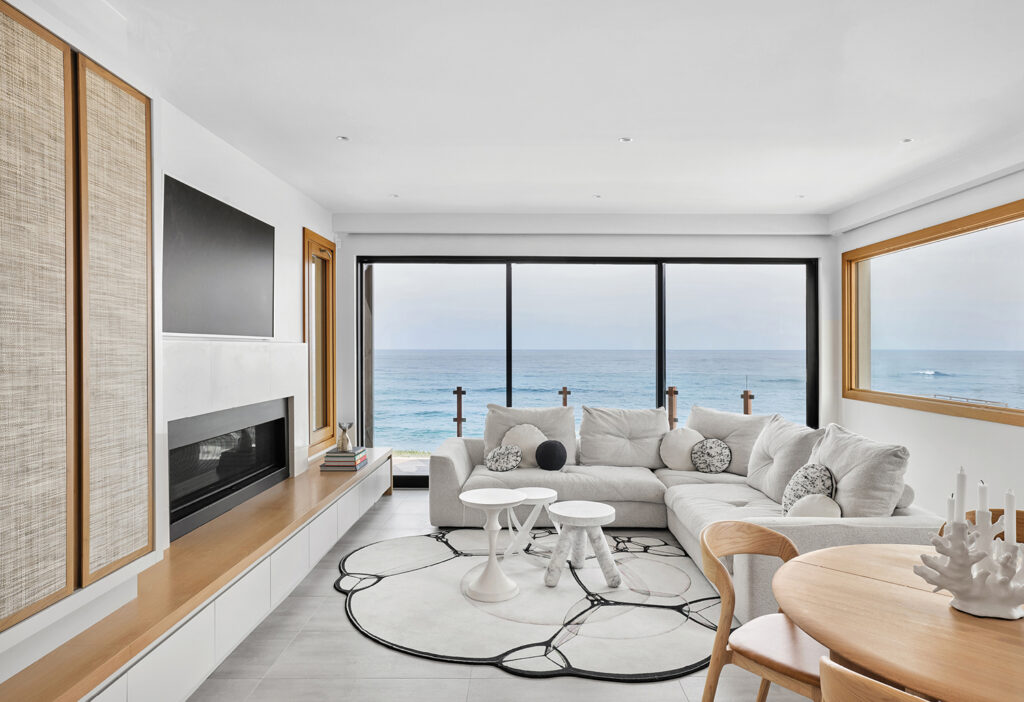 A living room with a large window overlooking the ocean.