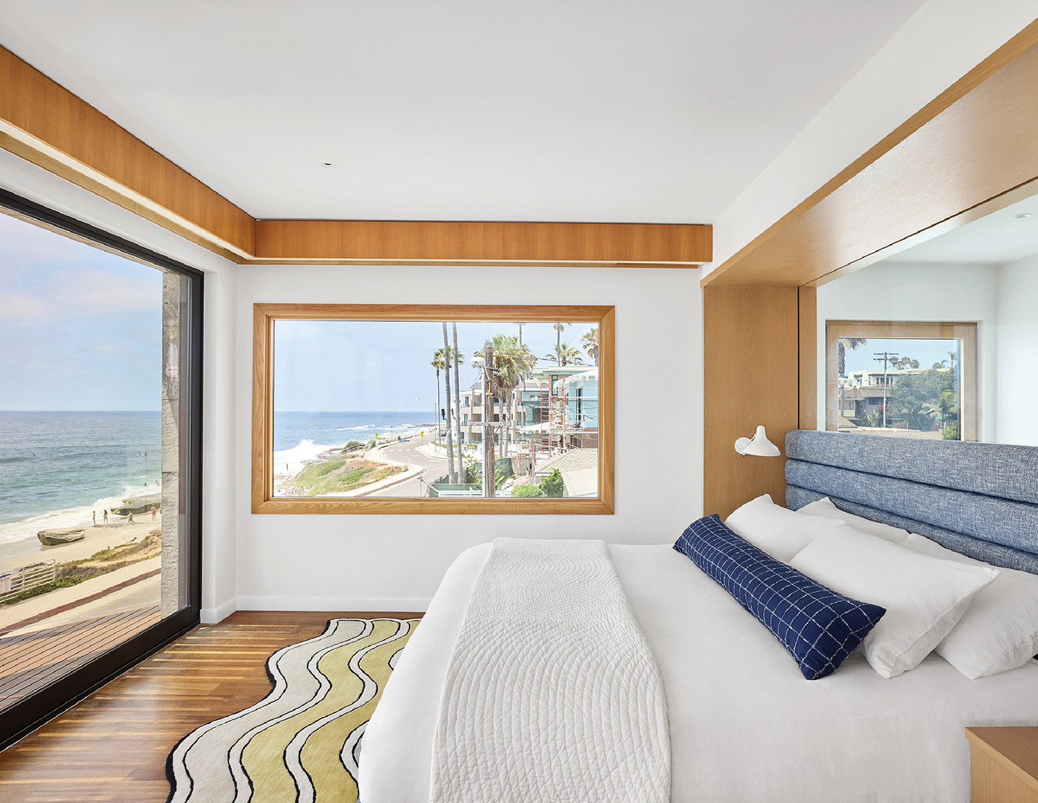 A bedroom with a large bed and a view of the ocean