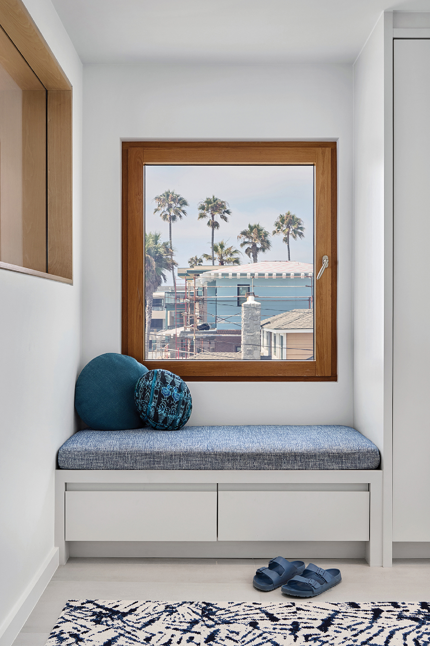 A window seat with a blue cushion and a blue pillow.