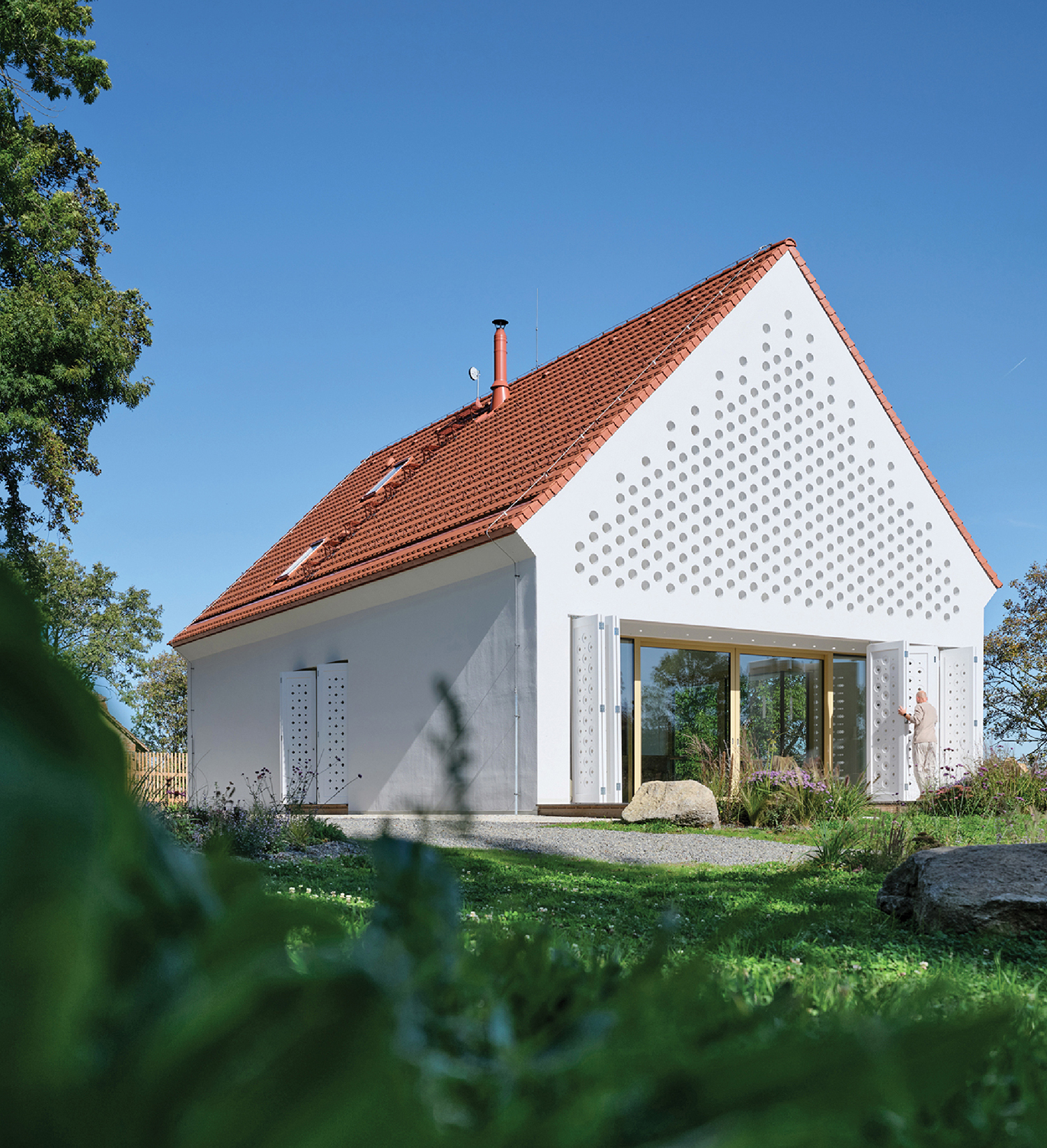 A house with a red roof and a white wall.
