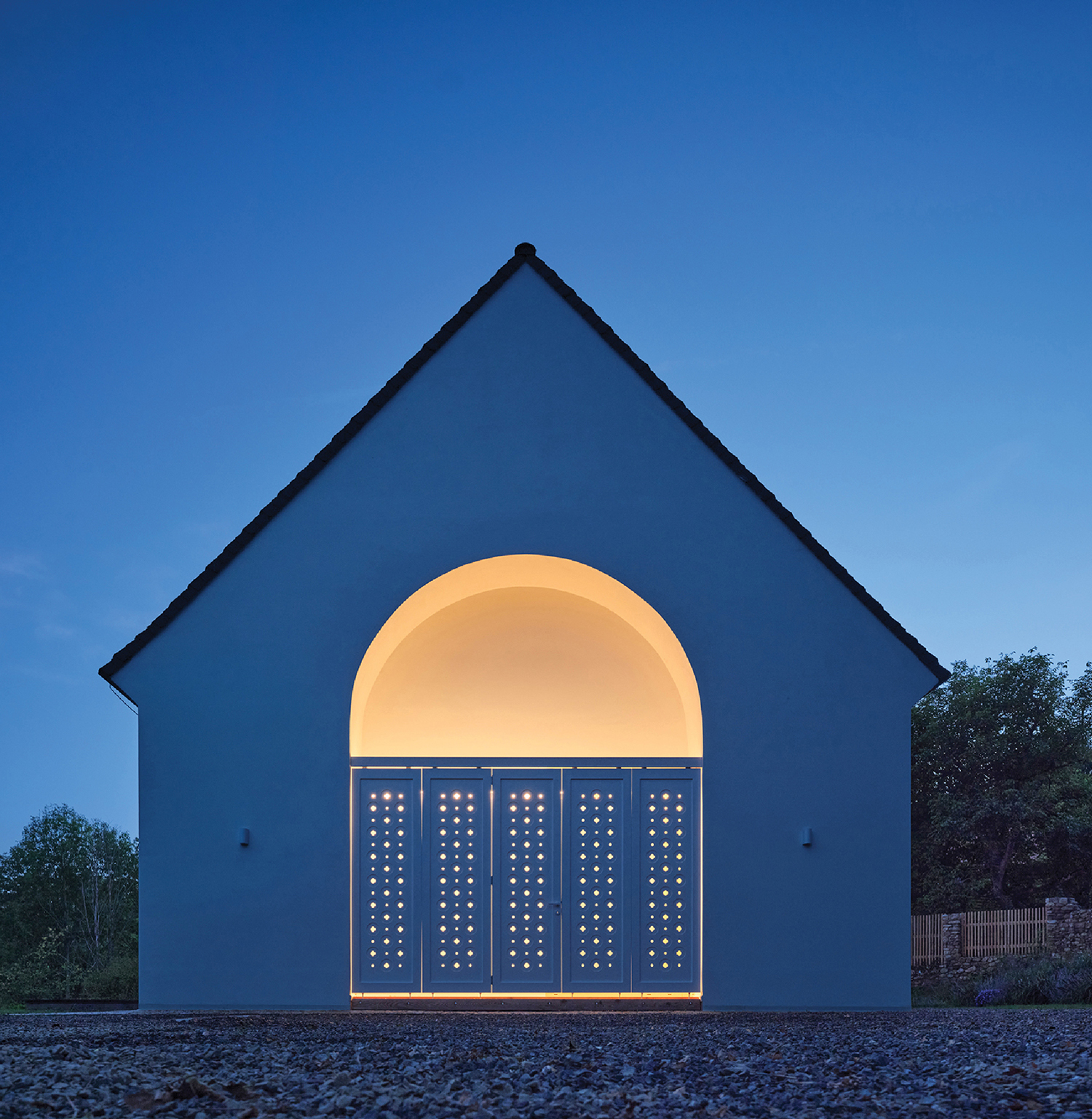 A white building with a light on the front.