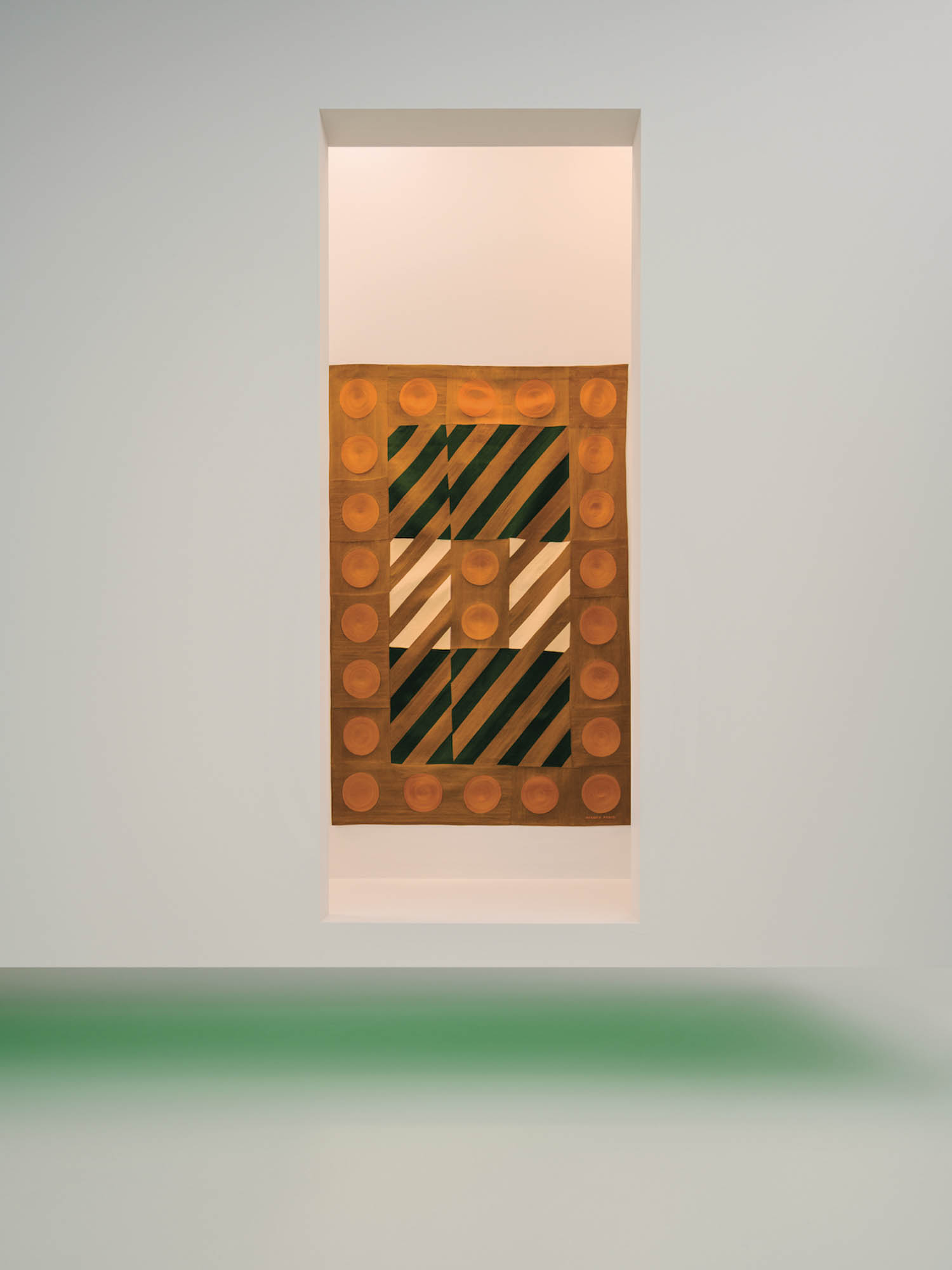 large orange rectangular artwork with green light on bottom