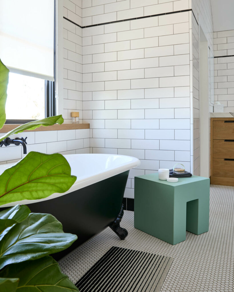 a green table near a clawfoot bathtub