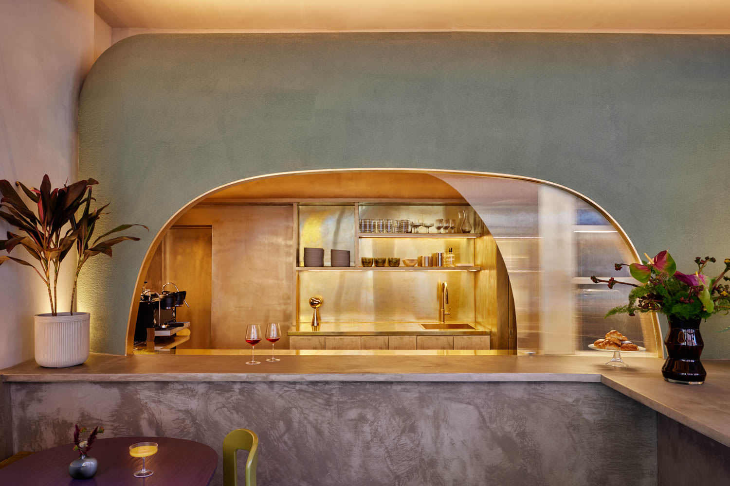 bar area of cafe with pastel green walls and marble counters