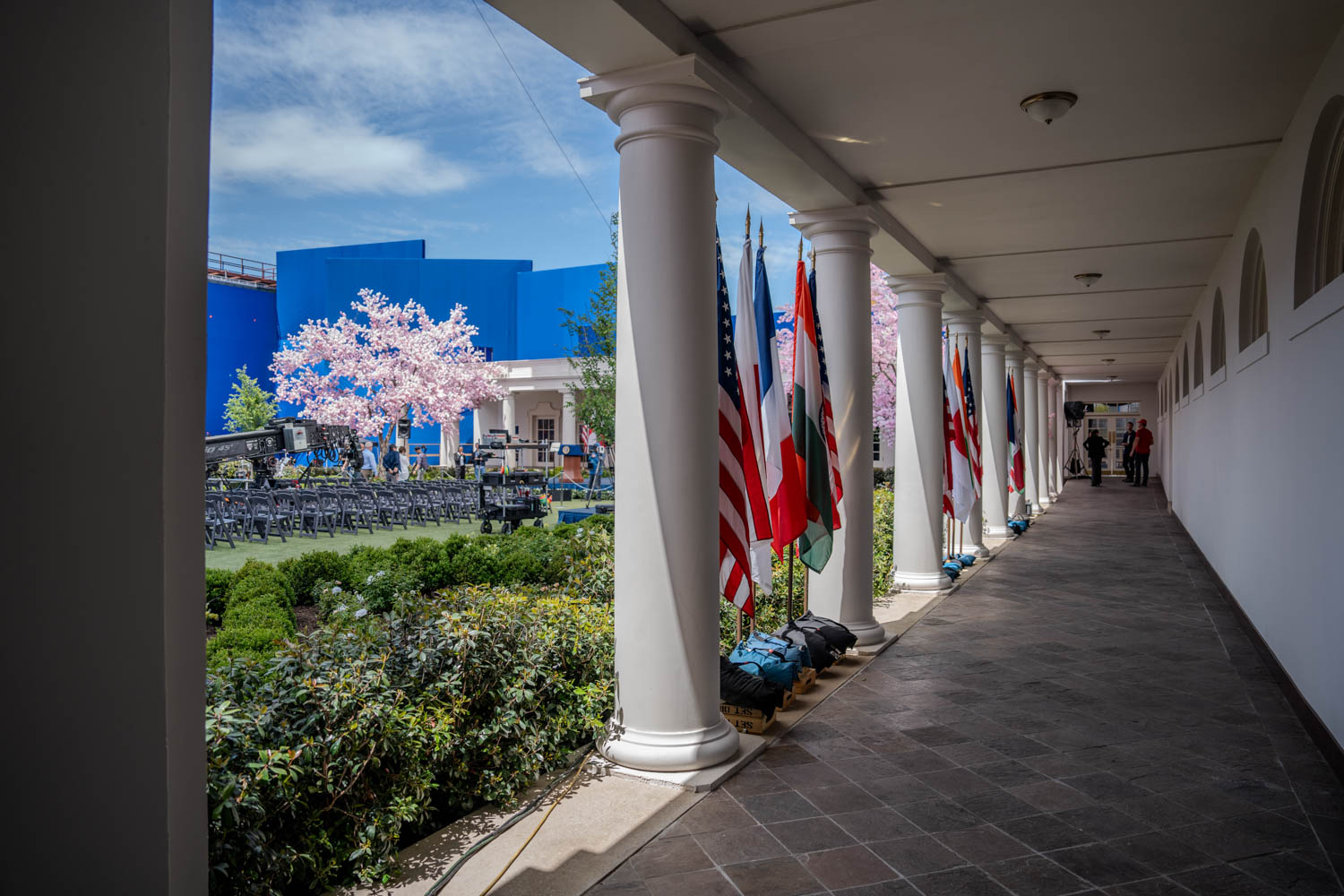 White House colonnade with multiple flags