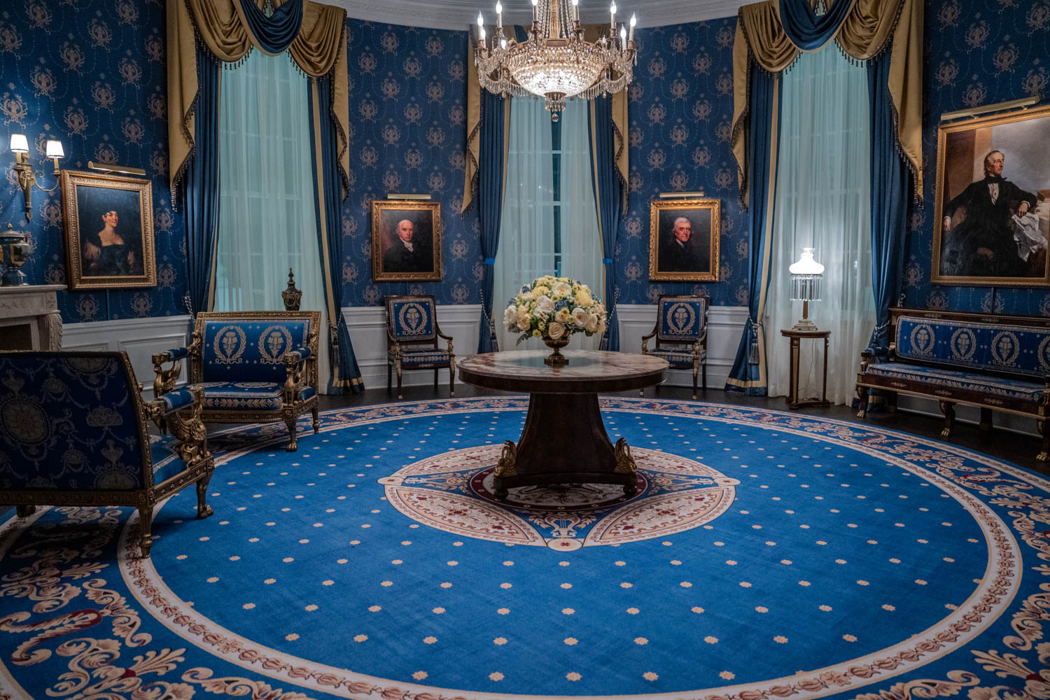 interior of White House blue room with dark blue carpets and gold drapes