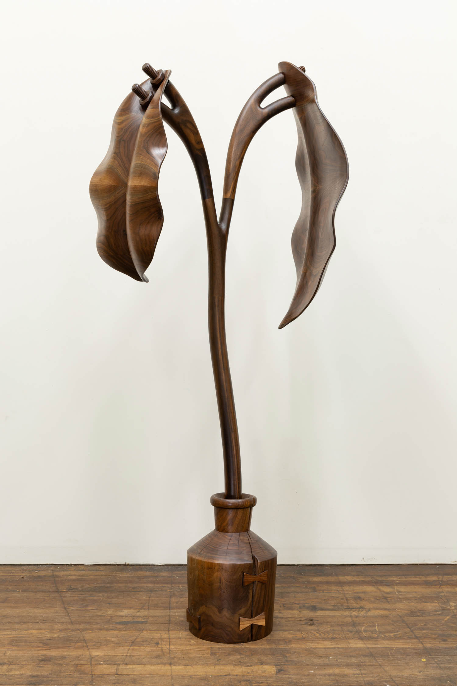 long bronze sculpture of plant with two leaves