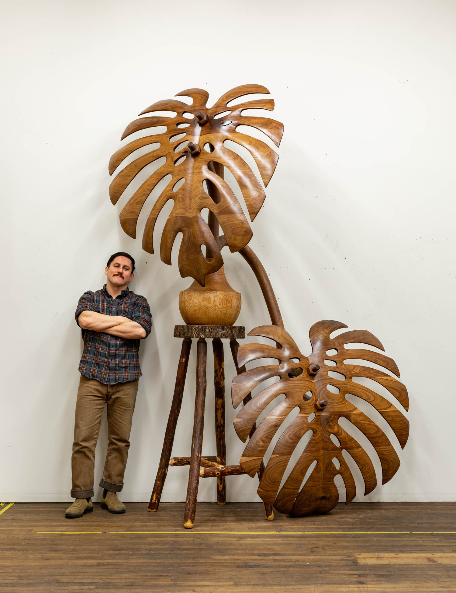 Raul de Lara standing next to bronze sculpture with leaves