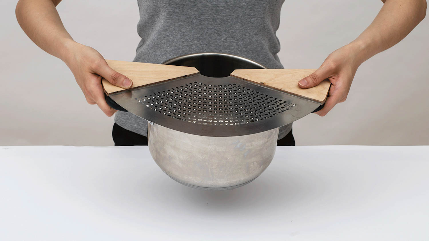 person holding a kitchen tool with grater
