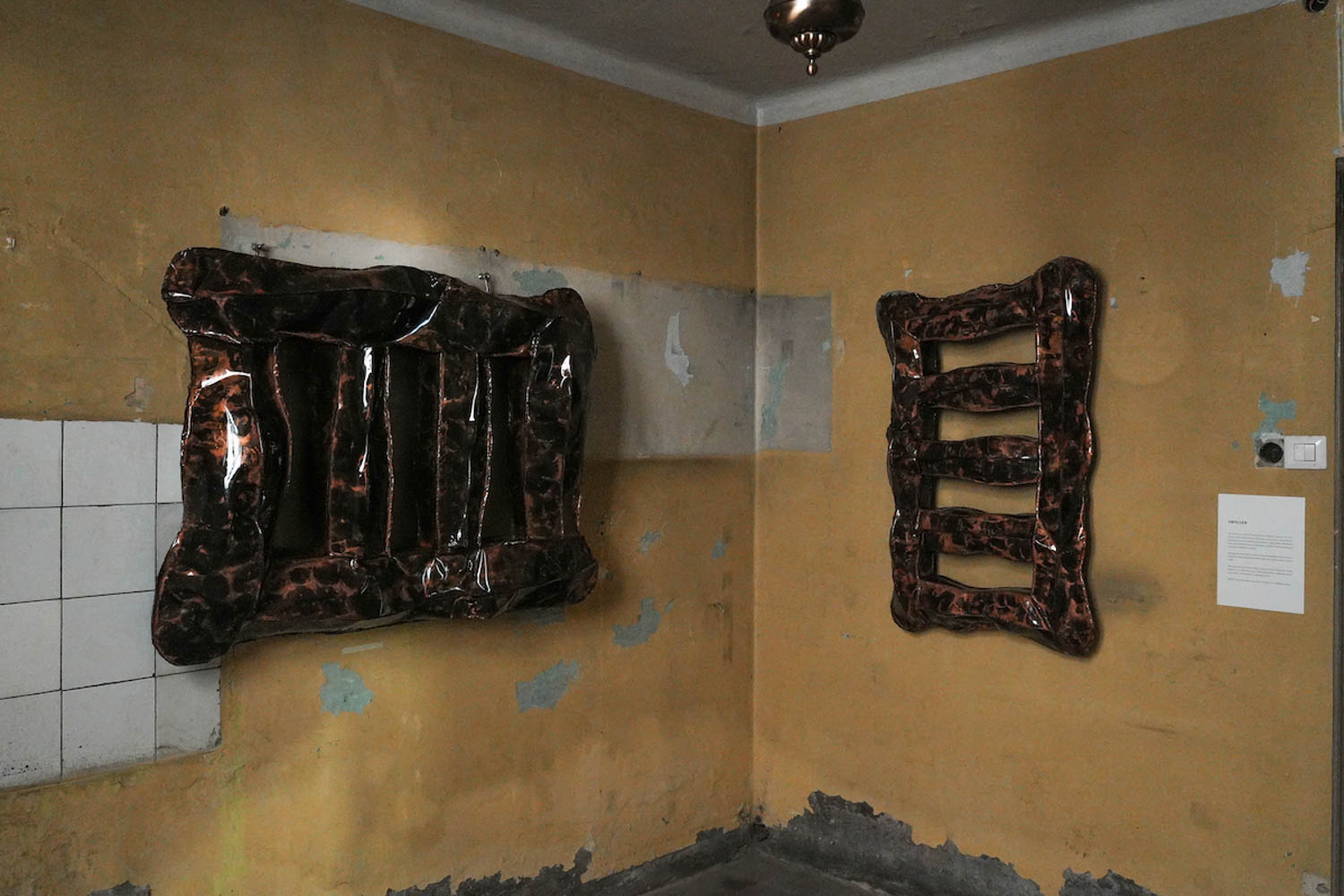two brown lacquered art pieces next to each other on wall