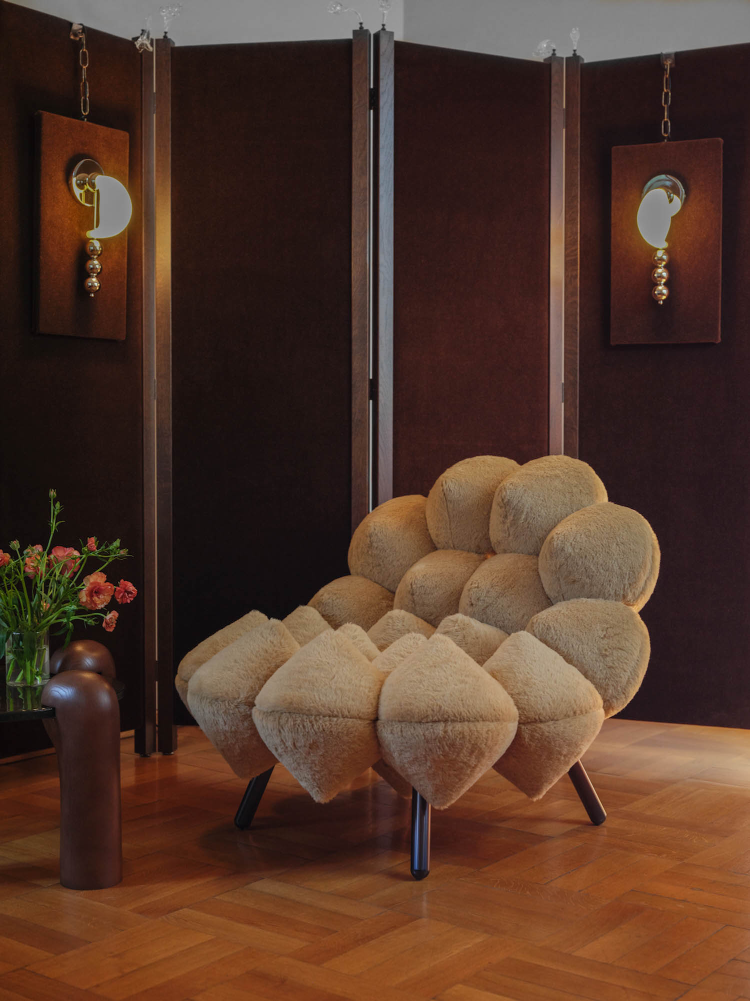puffy tan chair in a room with dim lights and wooden flooring