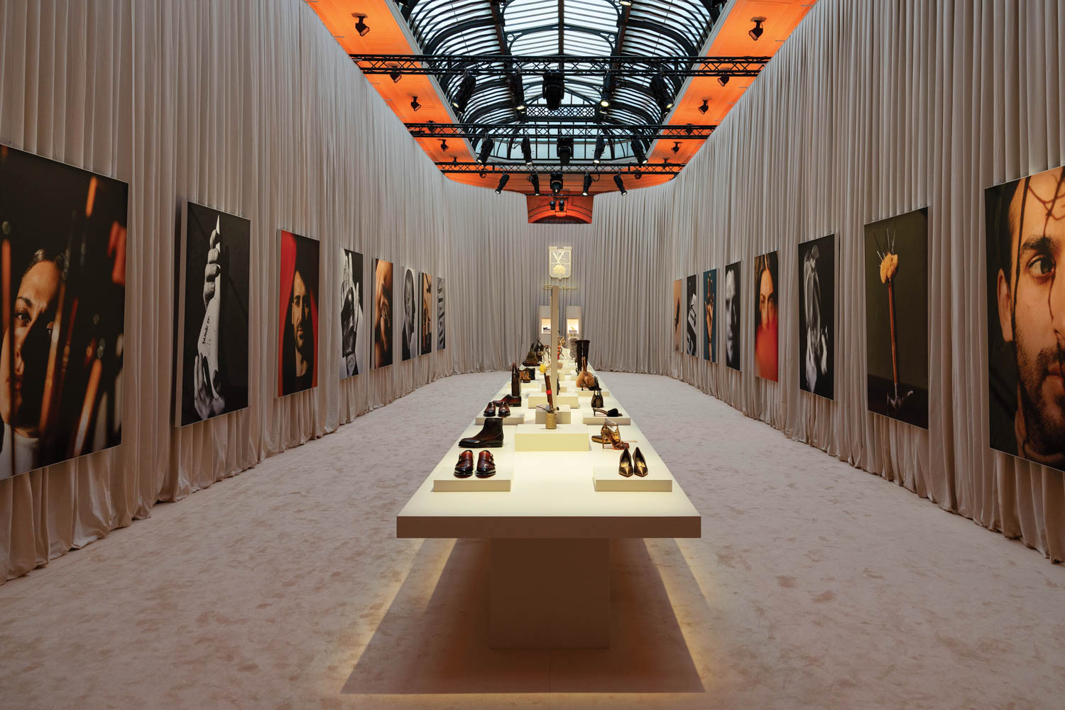gallery room with multiple artists on the wall and shoes in the middle