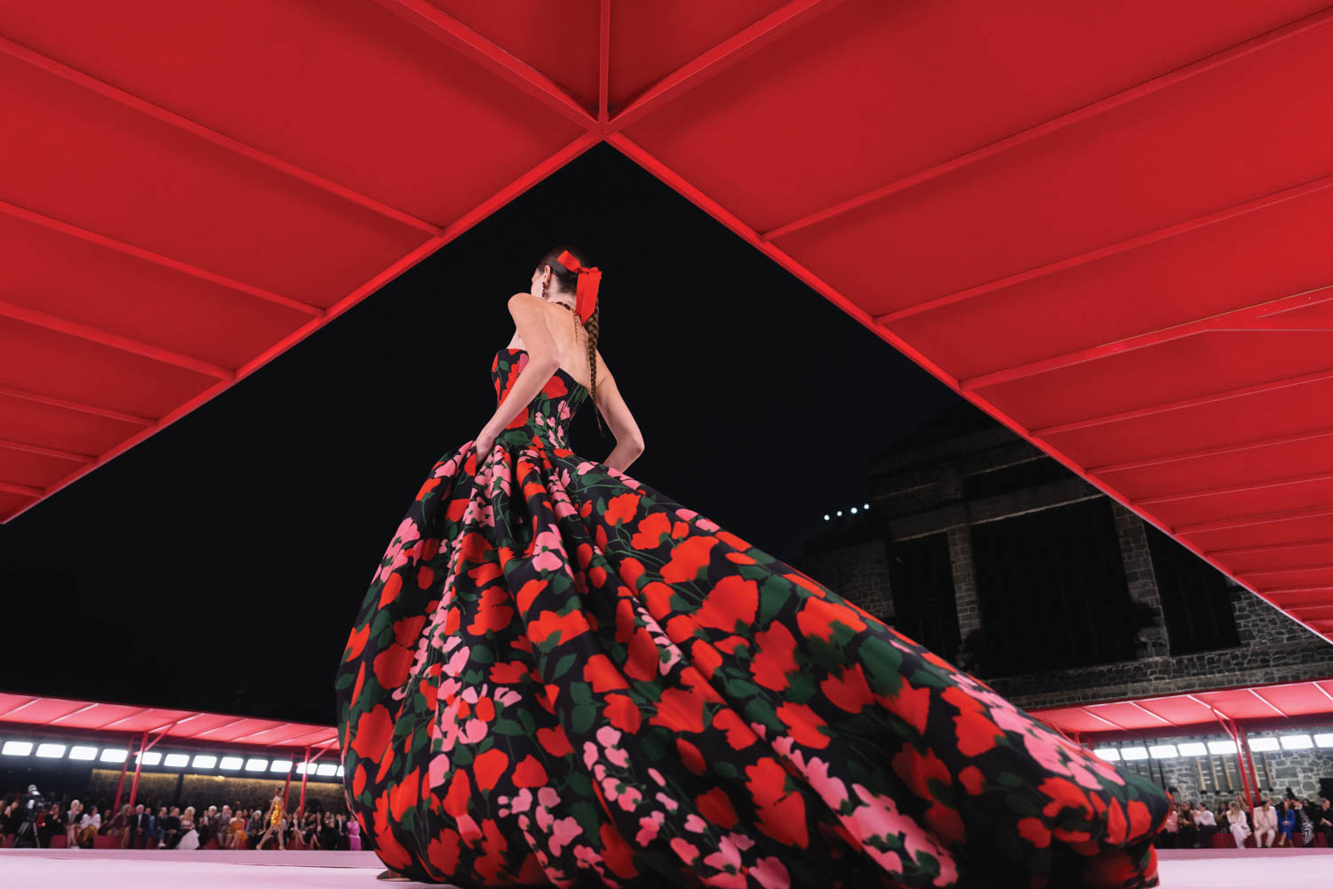 woman with bright dress full of red flowers