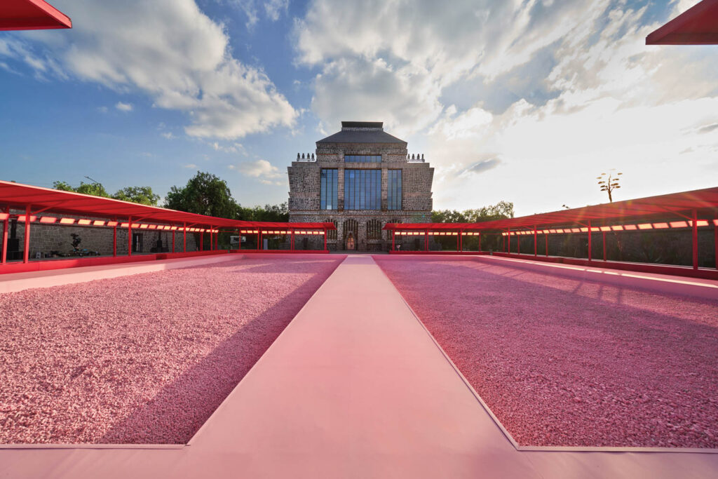 large building on a wide field of pink flowers