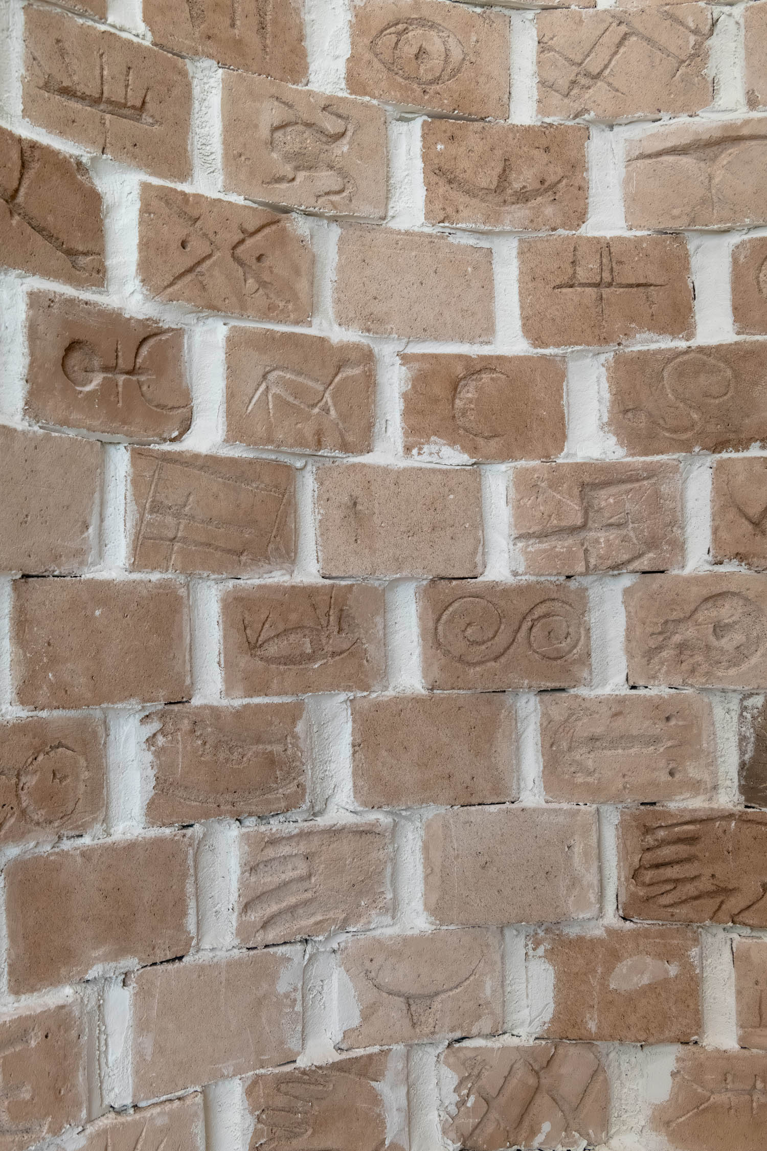 closeup of a brick column with intricate symbols