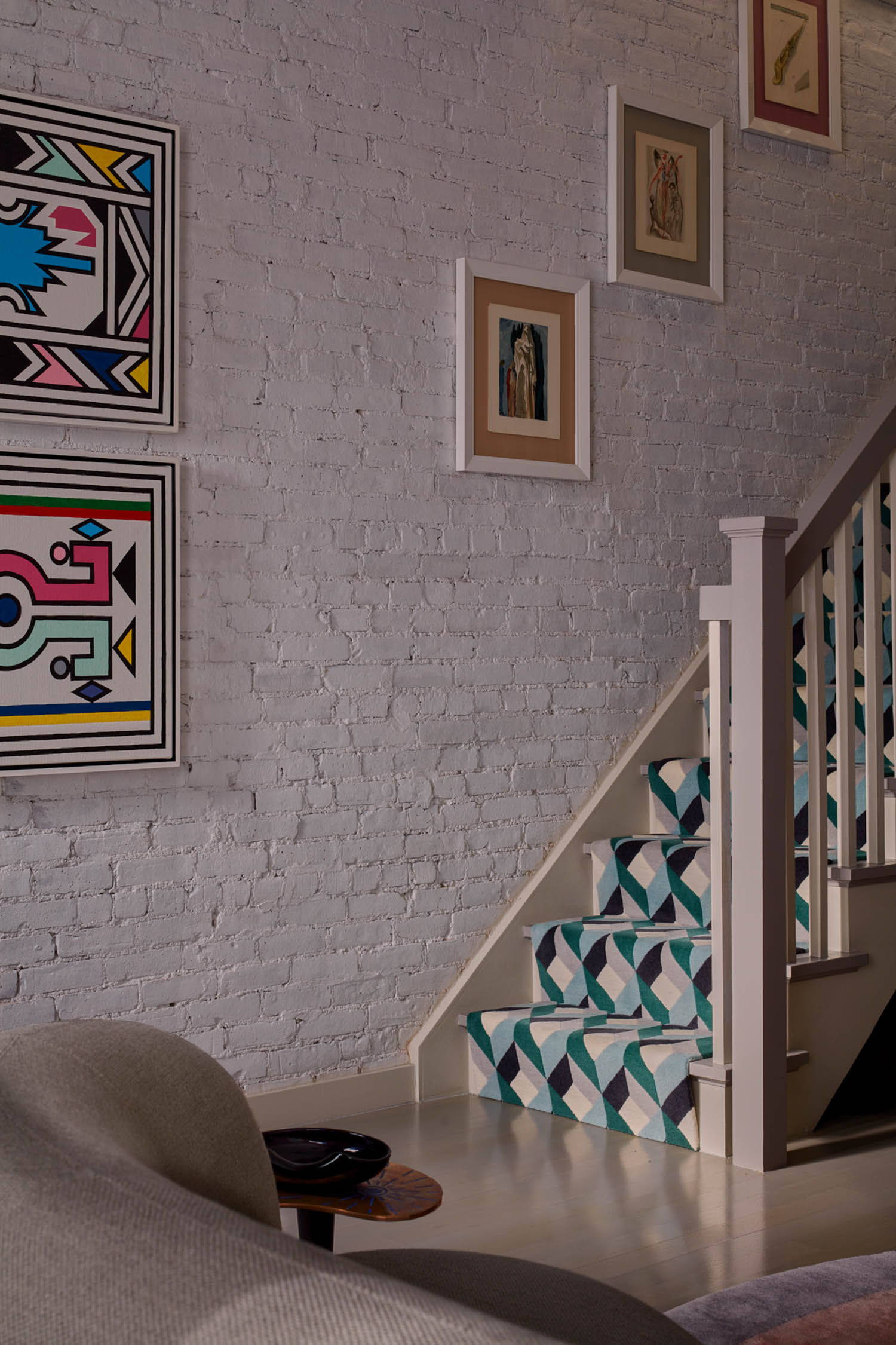 geometric stair runner alongside artwork on the walls