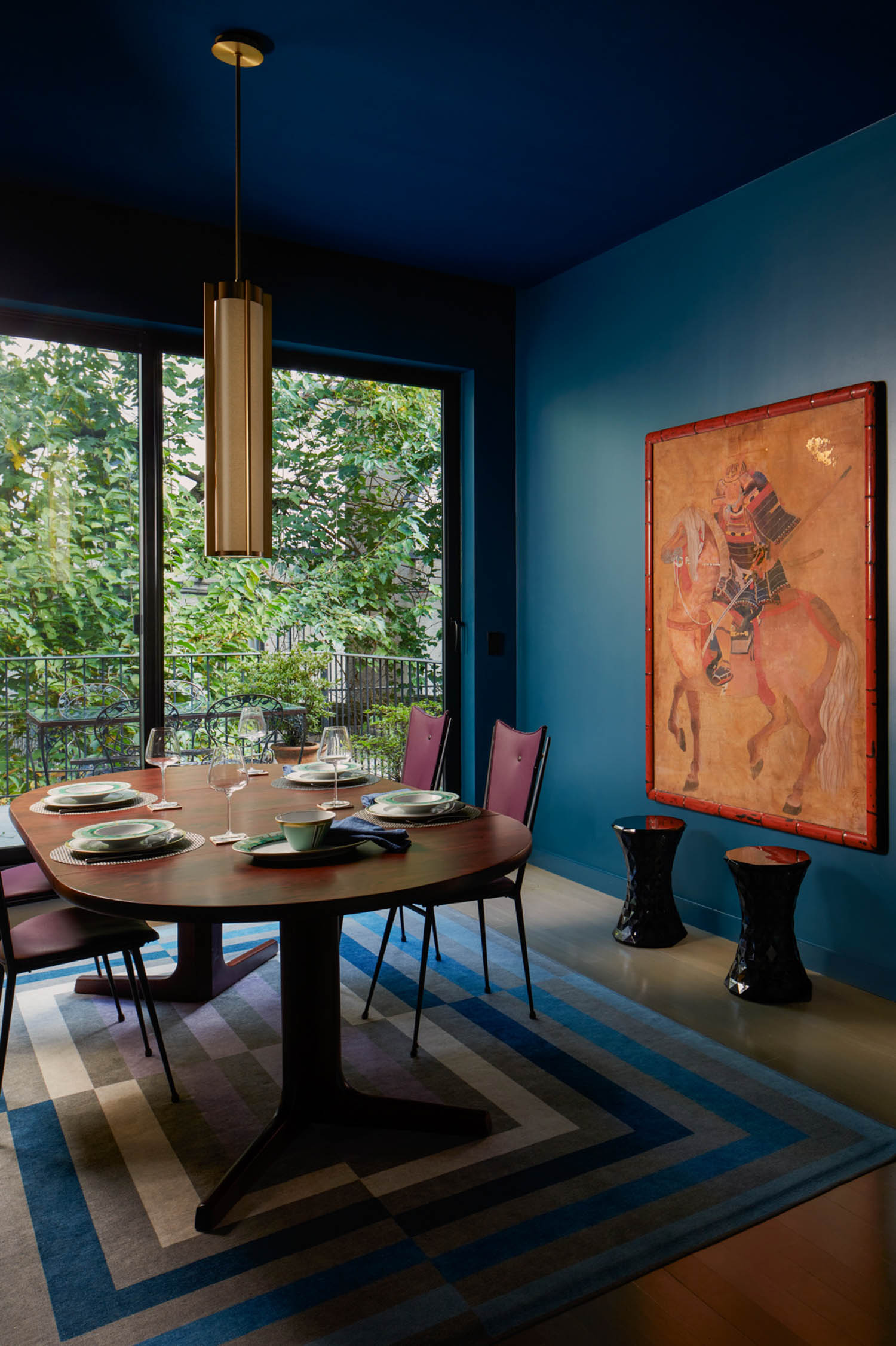 dining room with dark blue wallpaper and artwork on wall