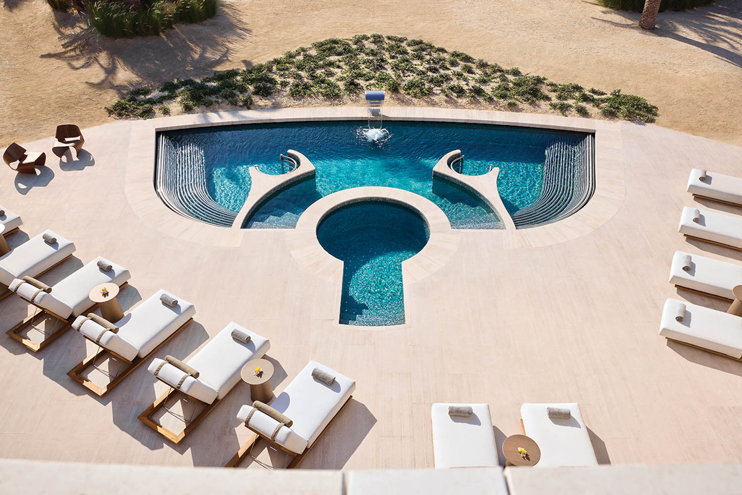 aerial view of white daybeds next to the pool