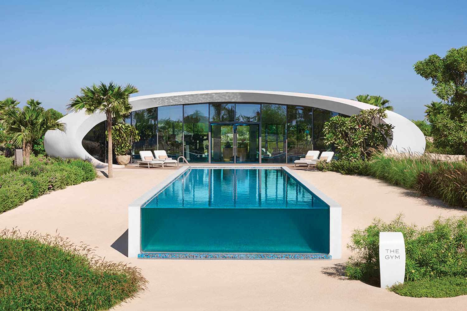 exterior of gym with large pool and chaise lounges