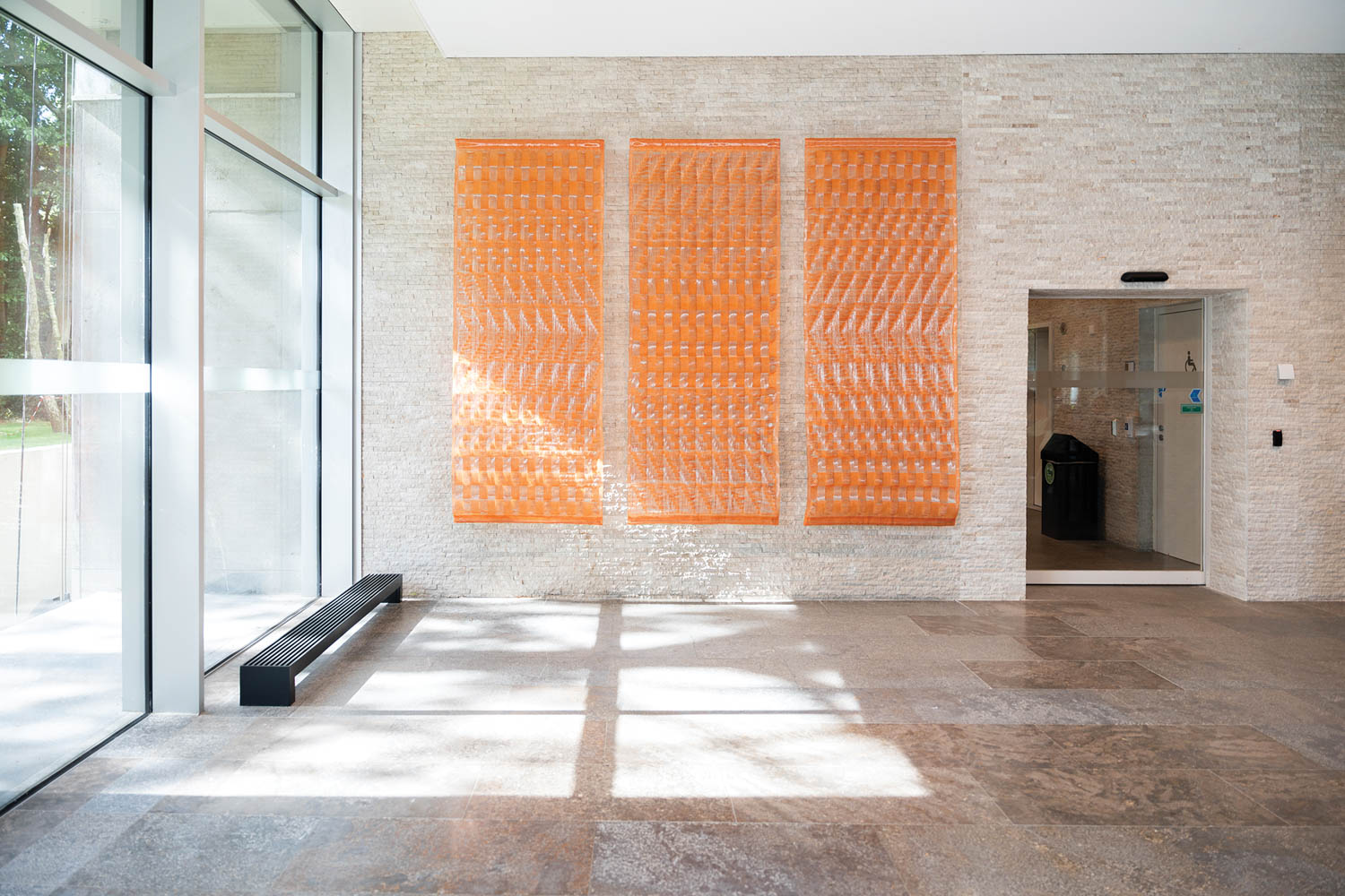 room with orange sculpture on wall
