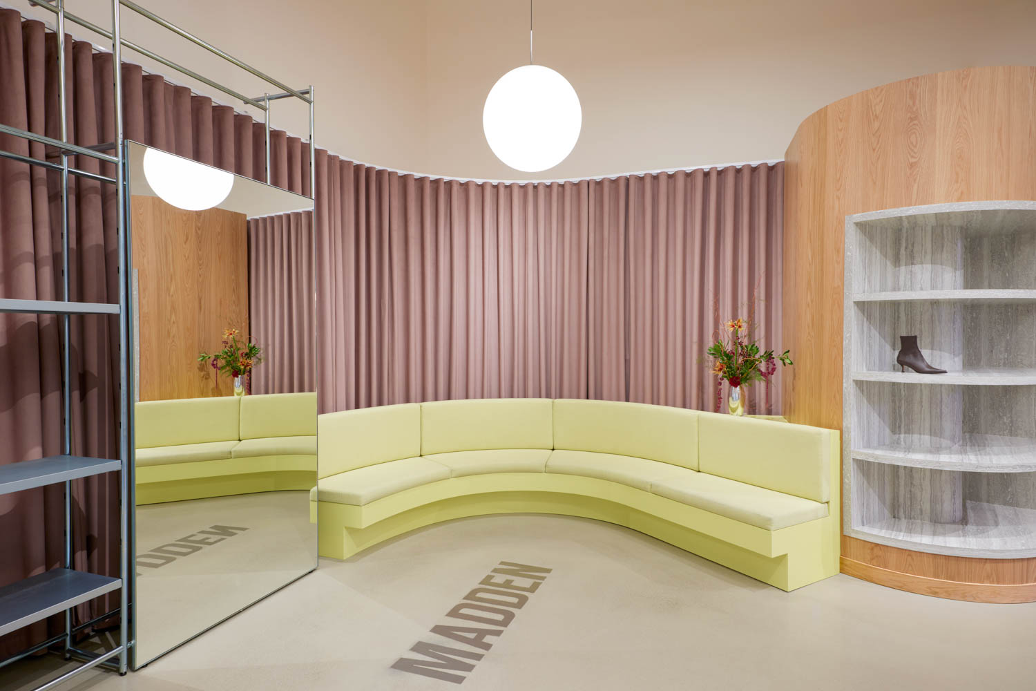 changing room area with curved yellow couch and pink drapes
