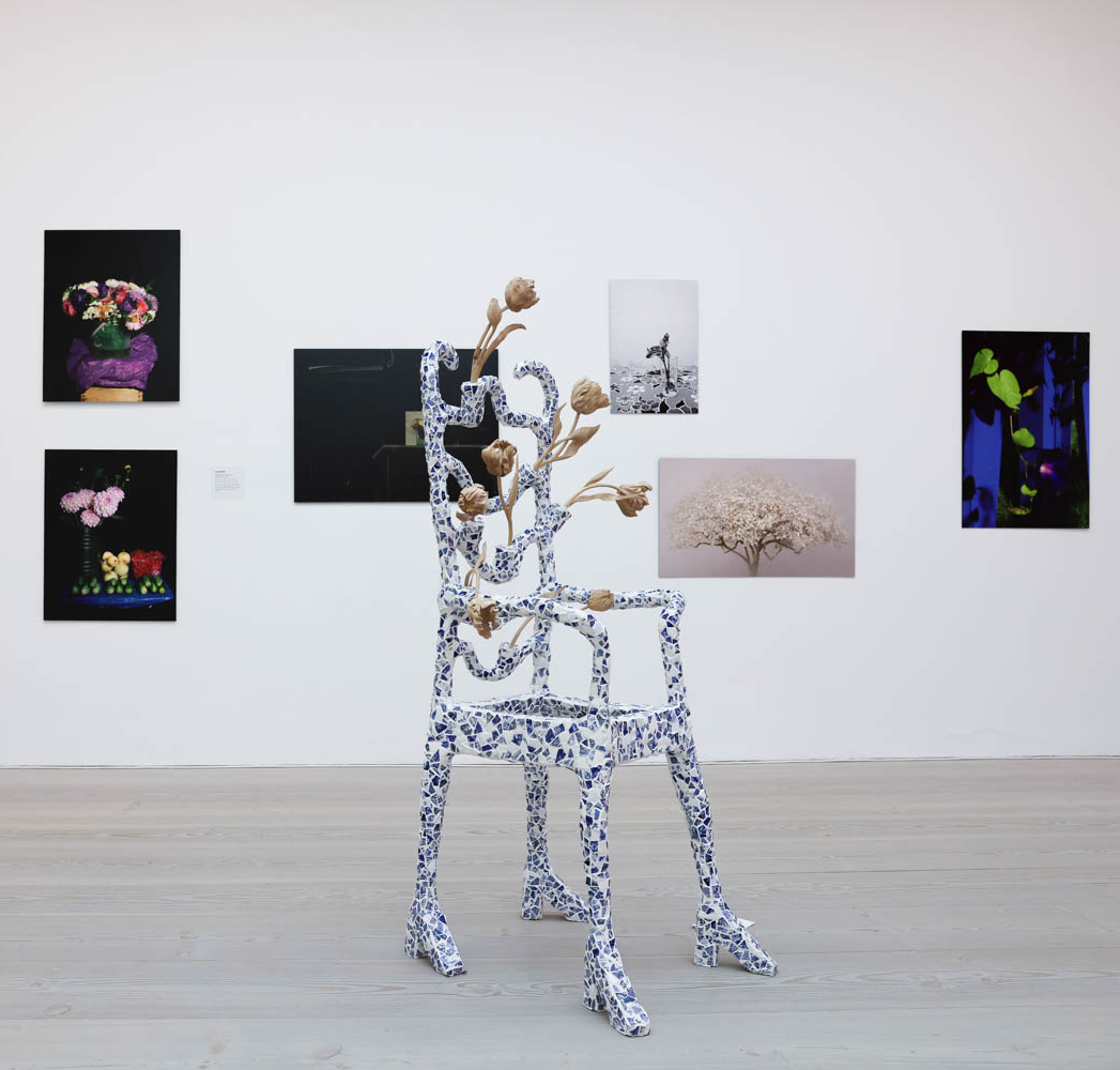 floral silver chair in front of paintings