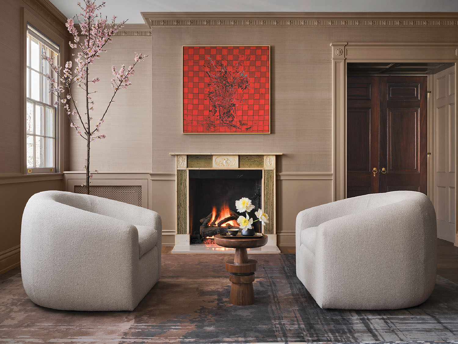 A living room with a fireplace and two chairs.