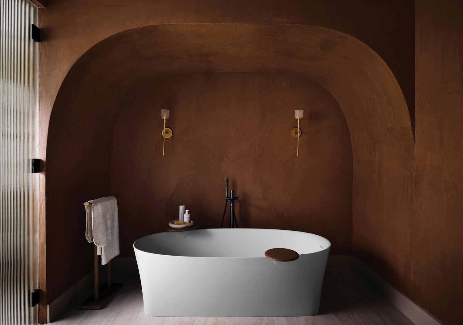 A bathtub in a bathroom with a wooden floor.