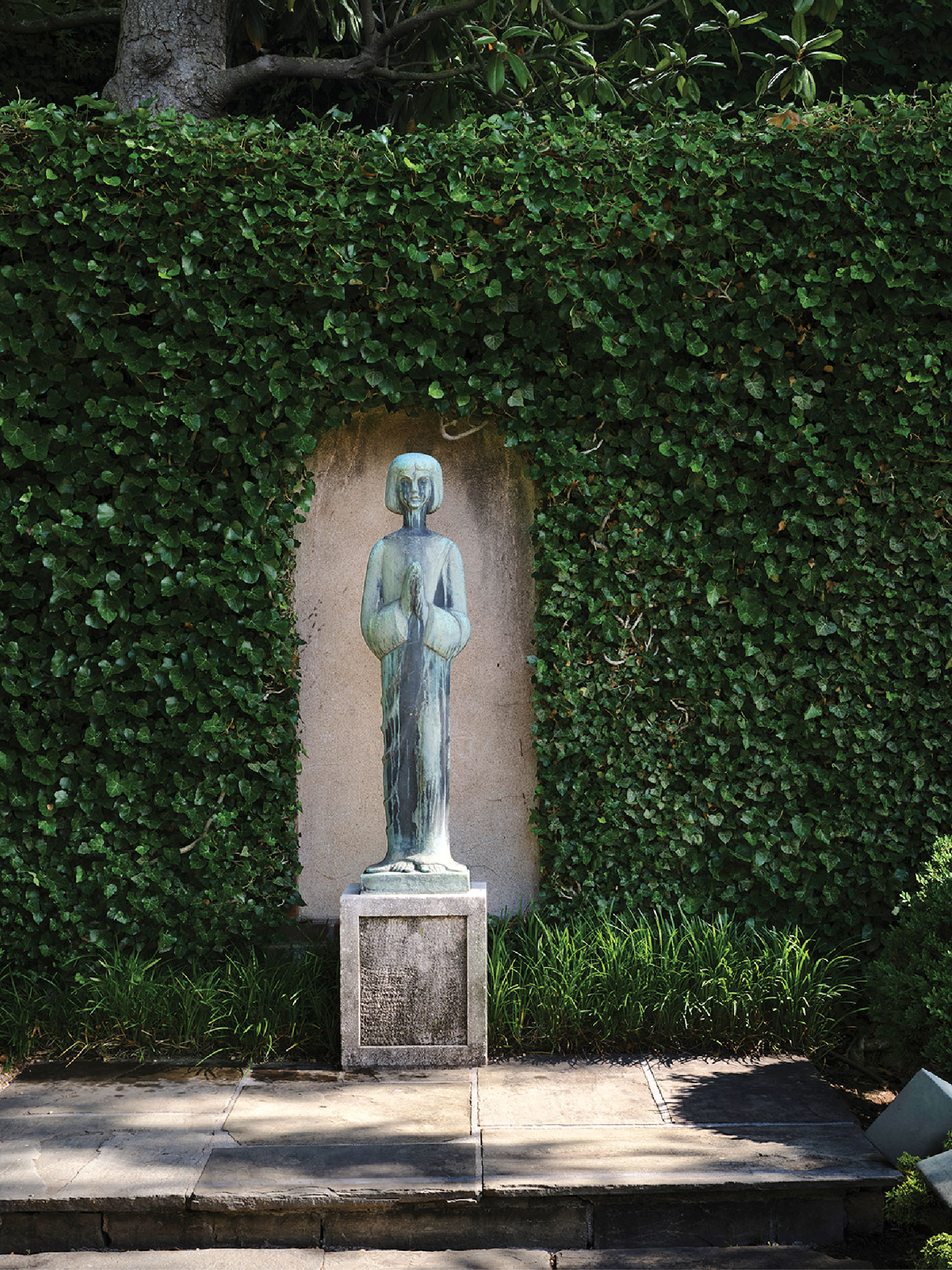 A statue of a woman in a garden.