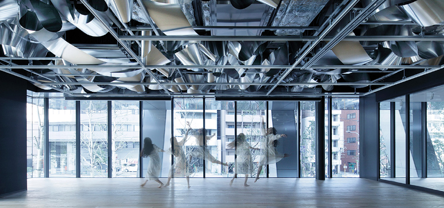 exterior shot of woman dancing in office with silver installation
