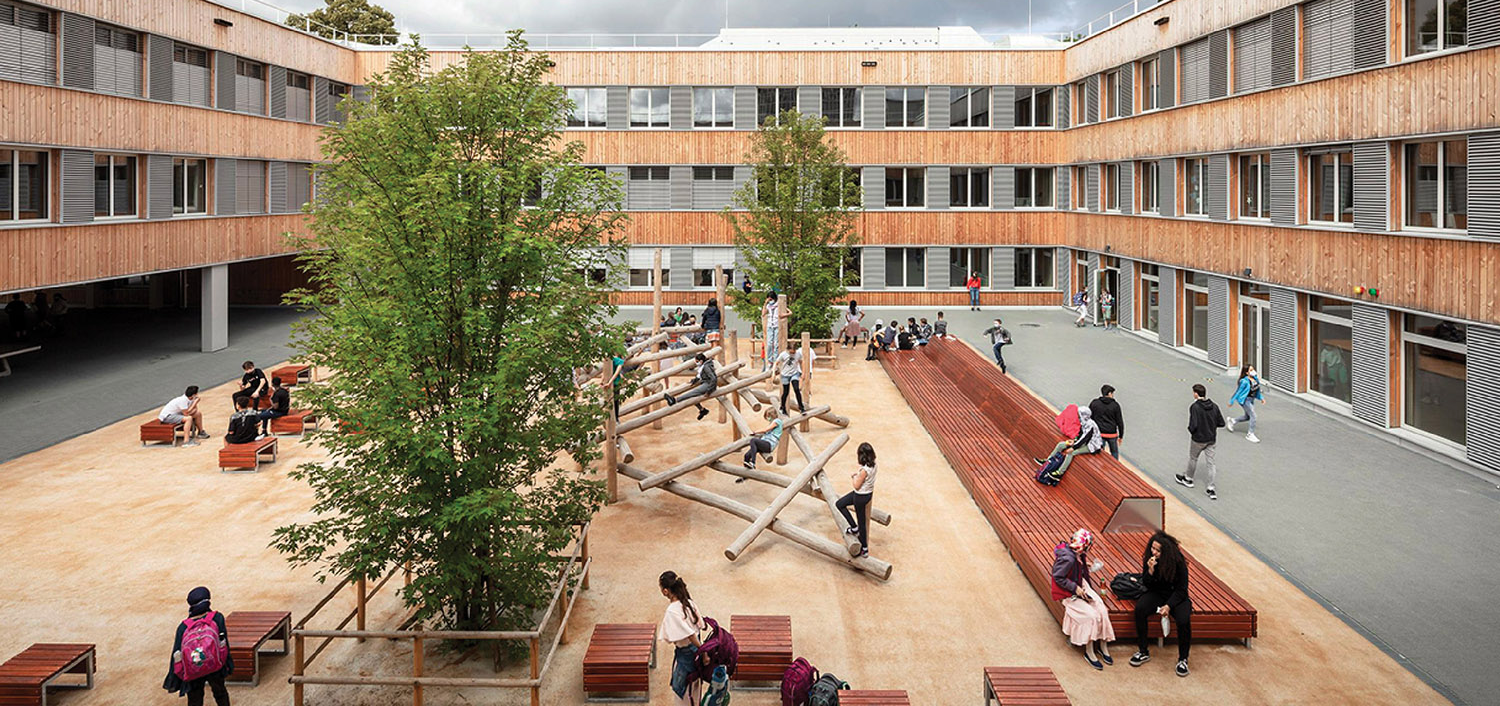 exterior courtyard of school with timber buildings and trees