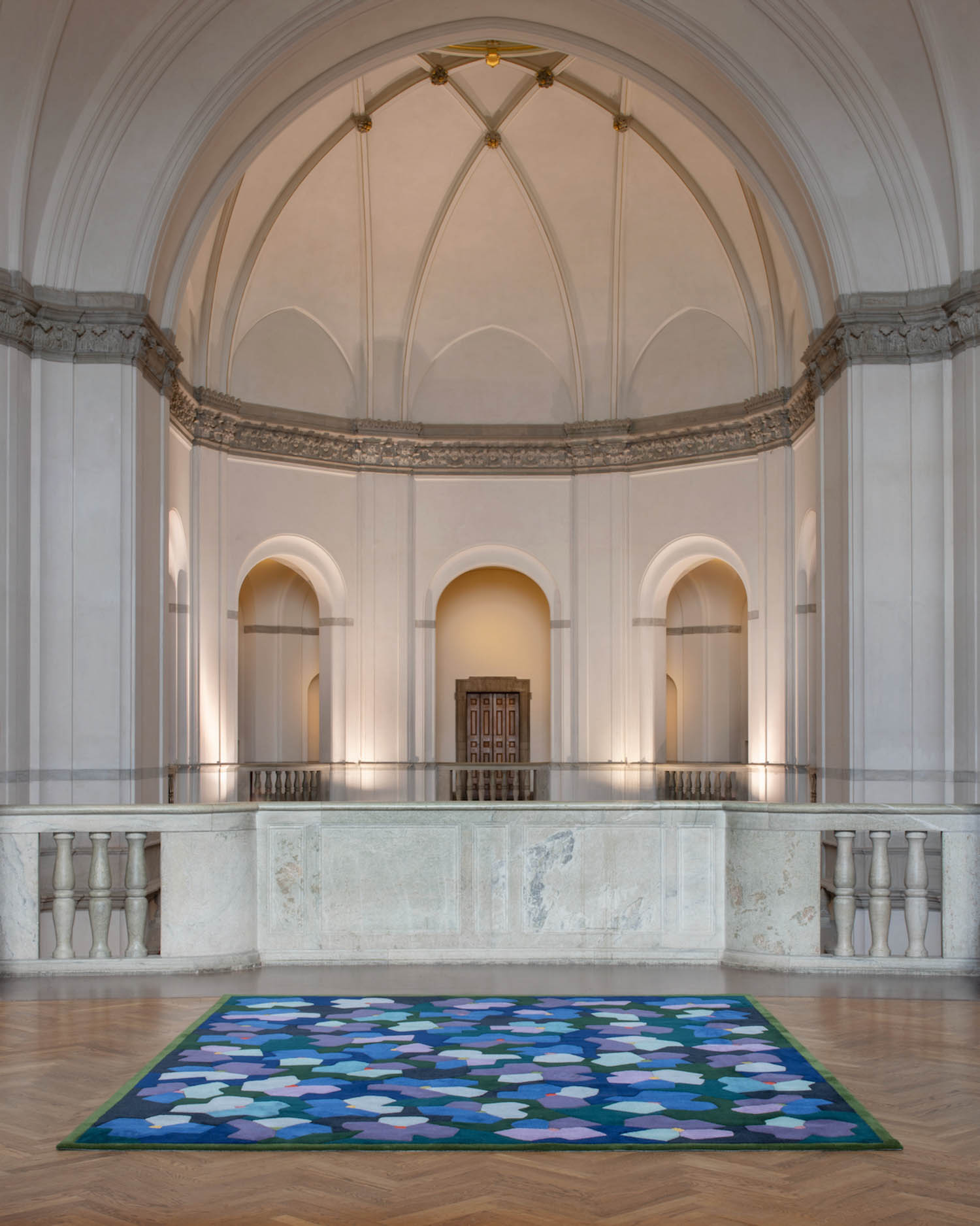 room with arched ceiling and blue rug