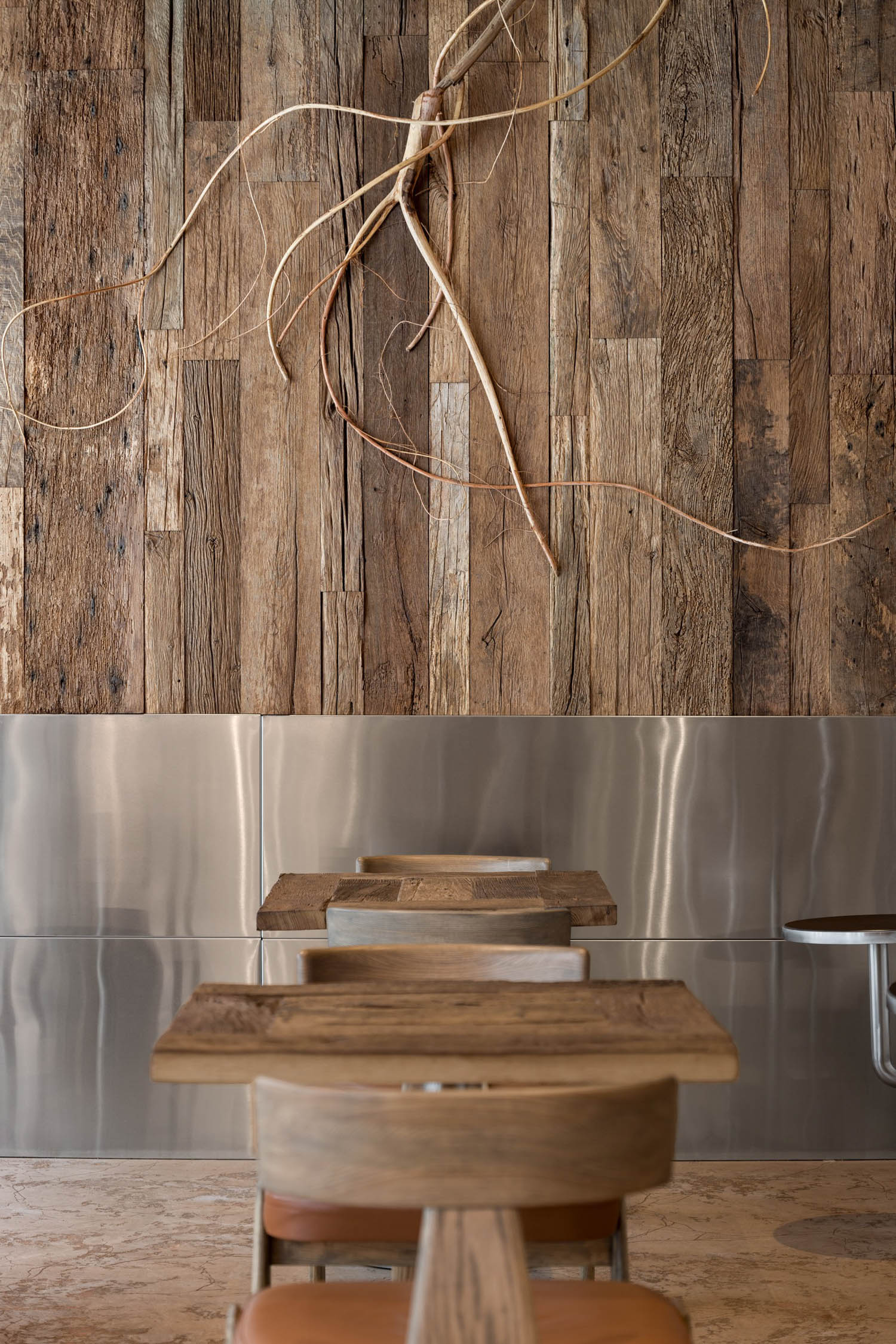 closeup of wood panels and wooden tables with chairs