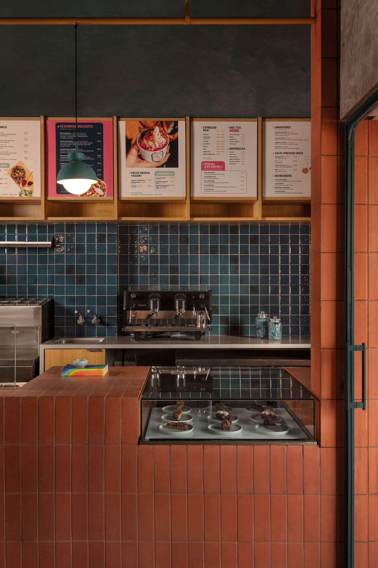 kitchen area with teal tilework and menu signage