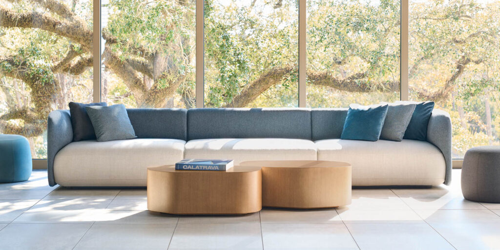 long white and blue couch behind low coffee tables