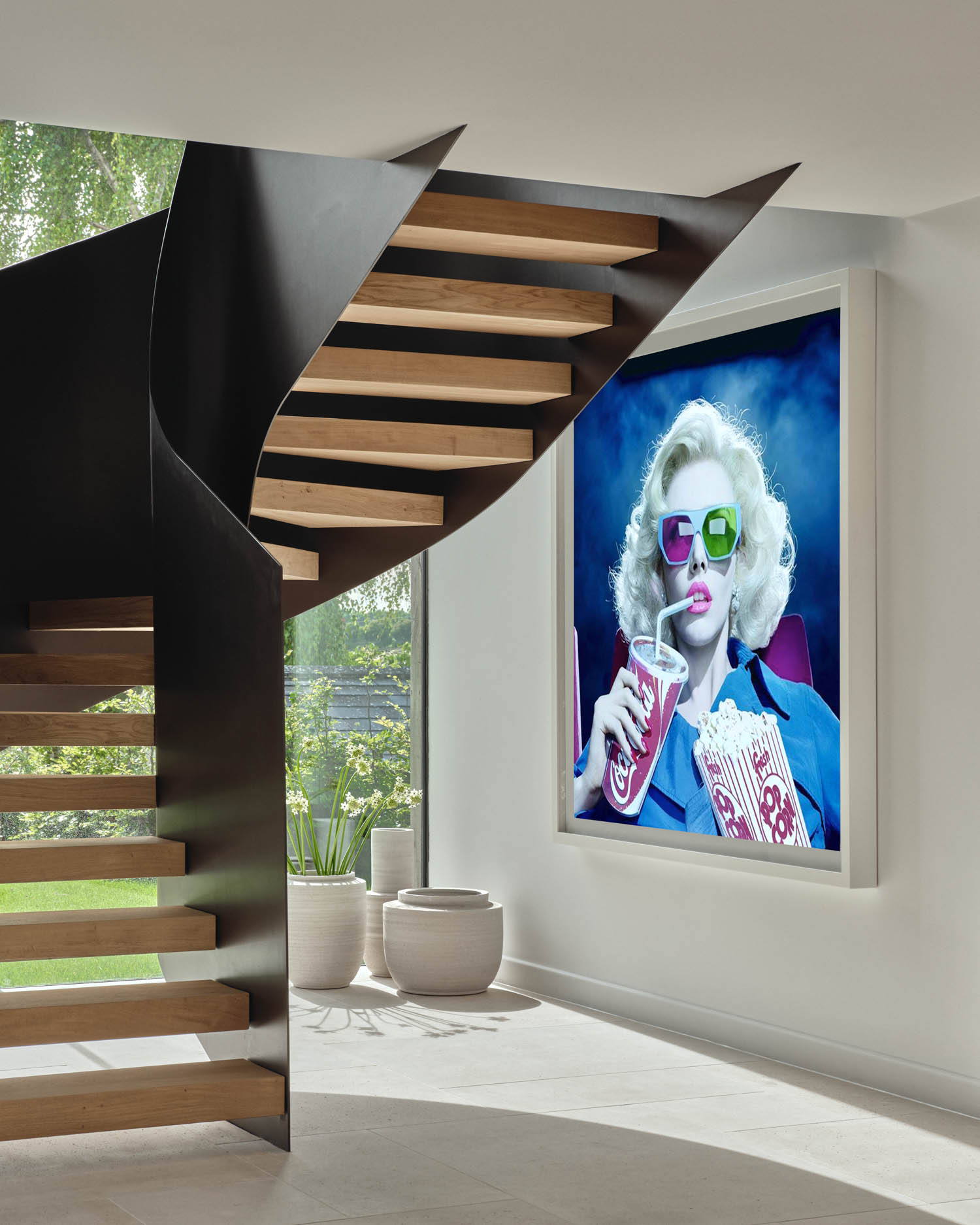 below staircase is a bold art piece on the wall