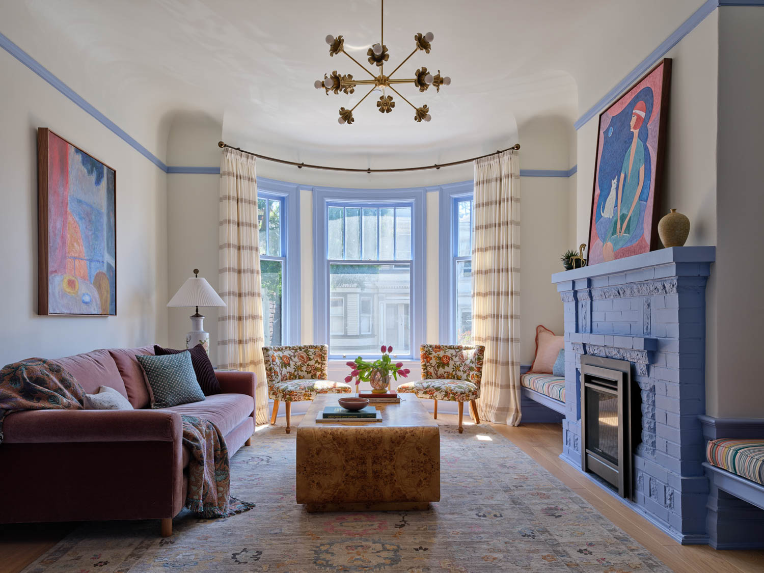 living room with blue fireplace and bay window