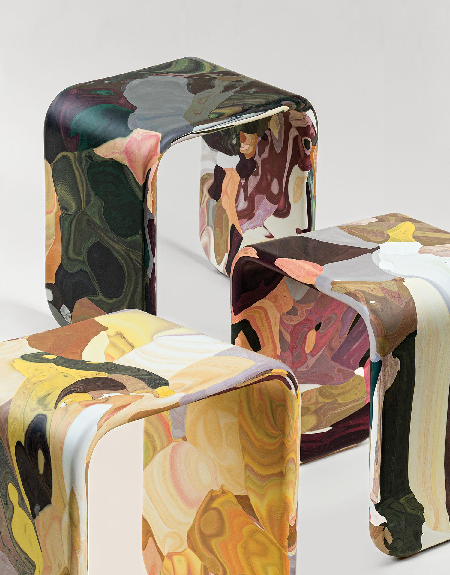 Three colorful stools with different designs on them.